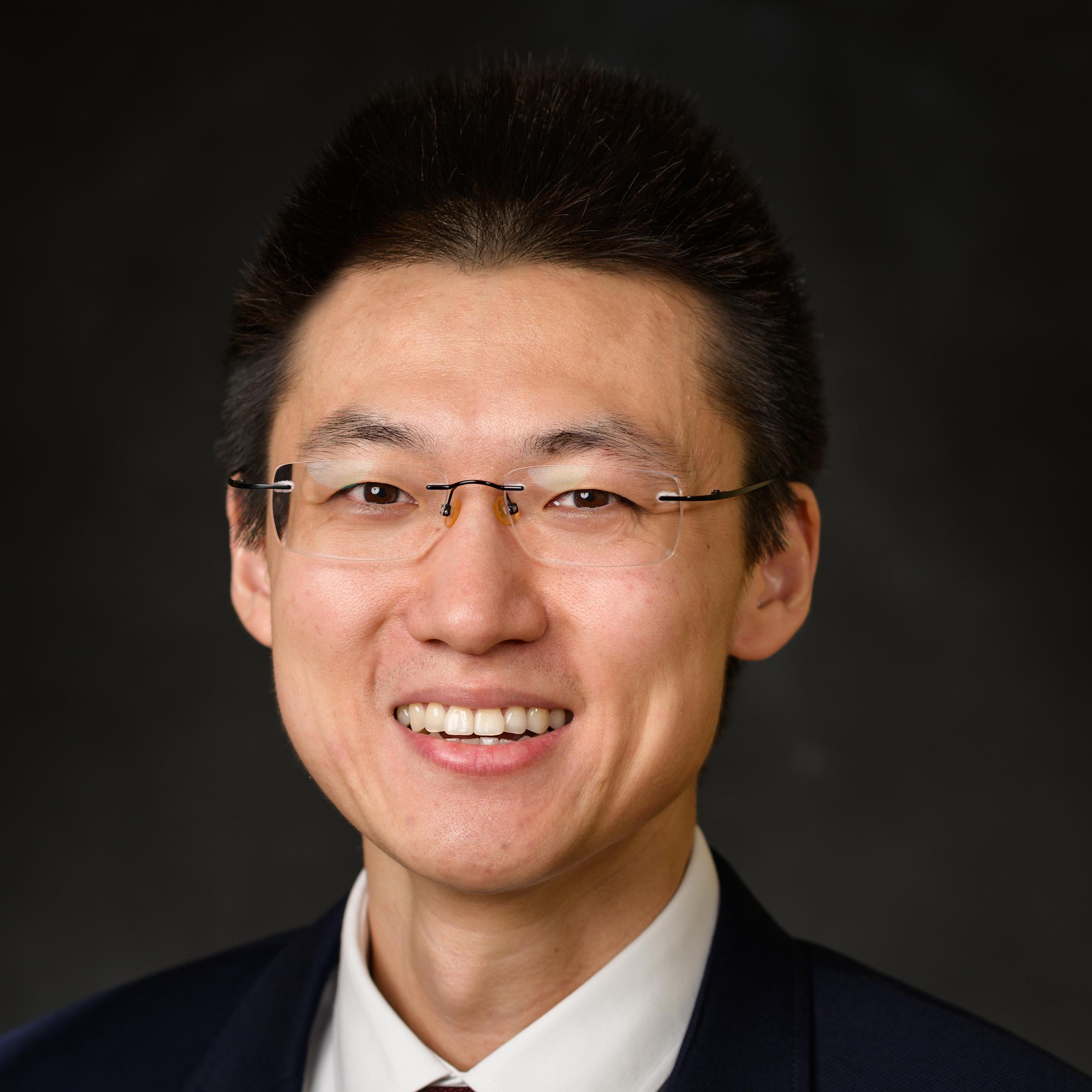 A professional headshot of Shang Wang