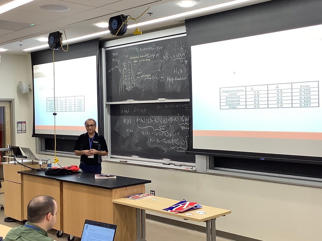 Choudur Lakshminarayan in front of a blackboard filled with statistical data. 