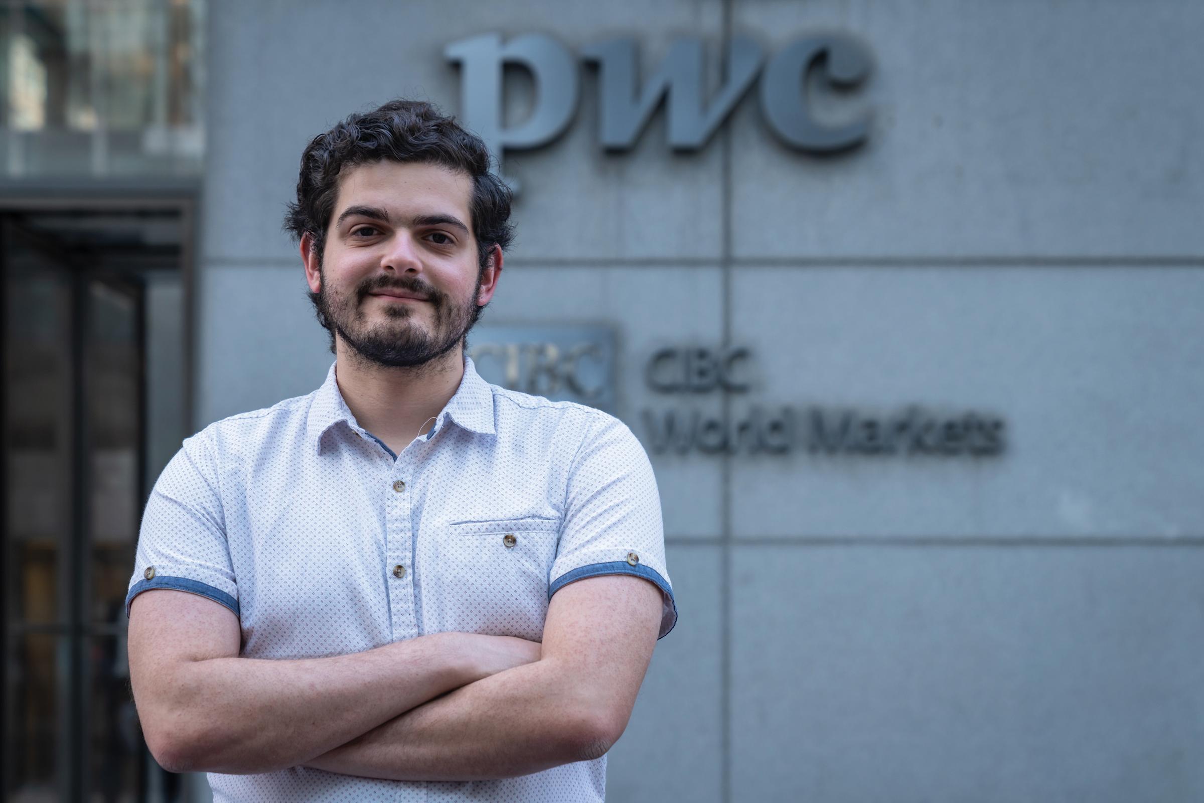 Matt Gordon smiles for the camera in front of PWC building.