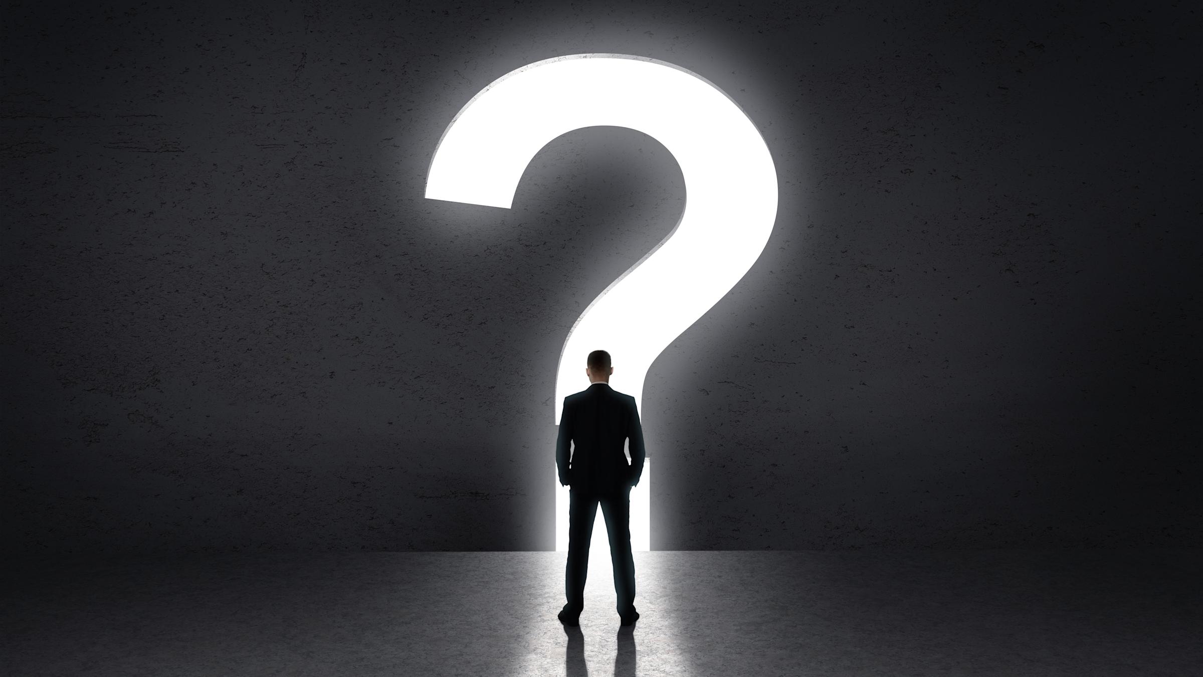 Person standing in front of large question mark