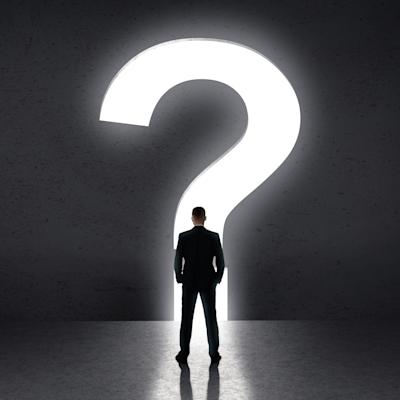 Person standing in front of large question mark