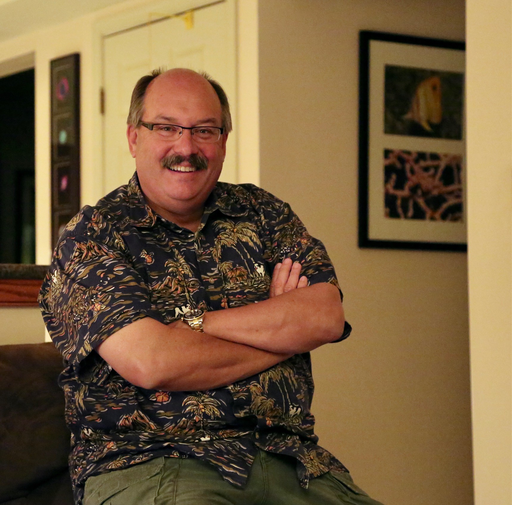 Dr. Steven D. Young ’78 smiles at the camera while sitting with arms crossed