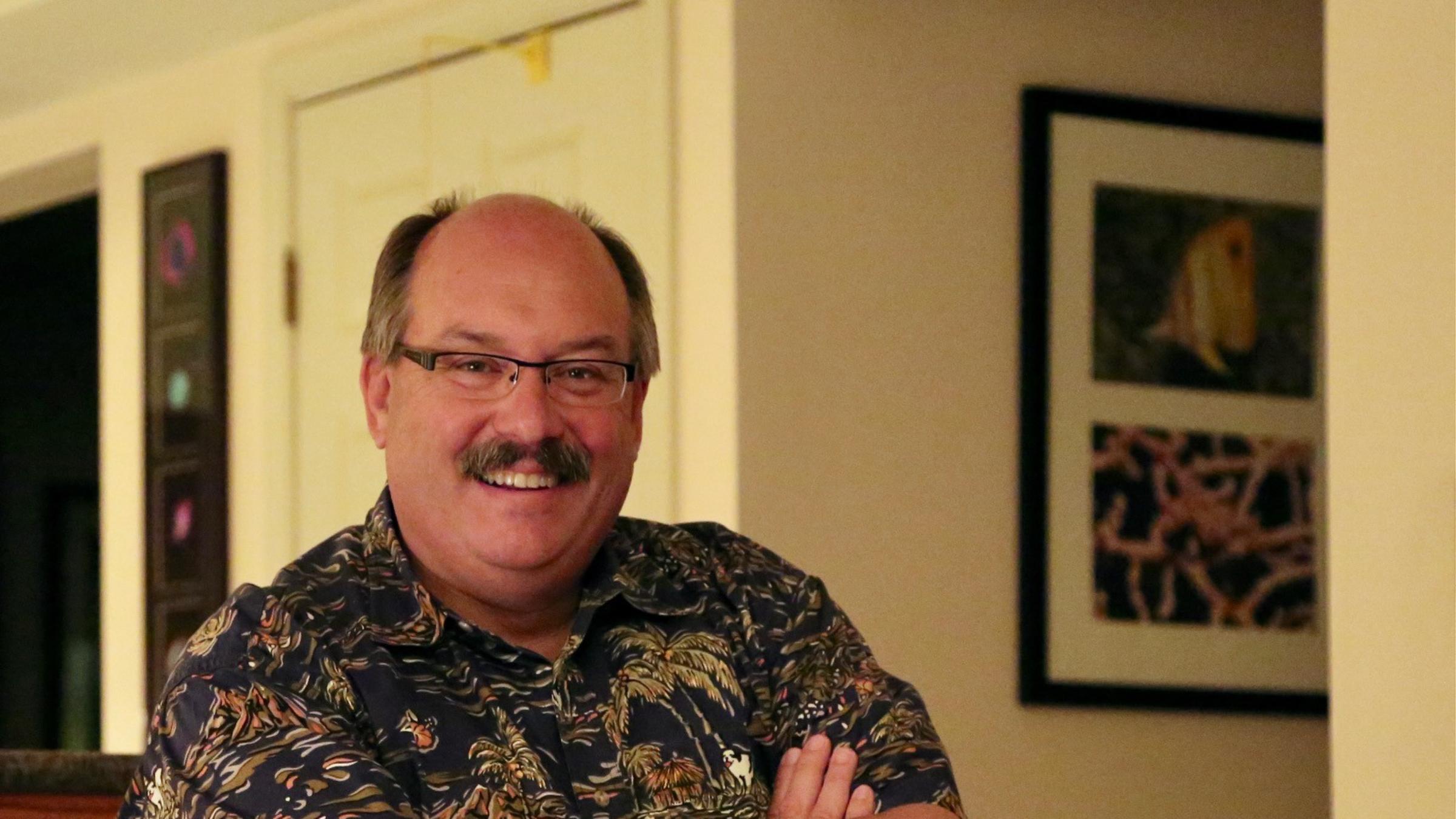 Dr. Steven D. Young ’78 smiles at the camera while sitting with arms crossed