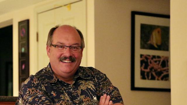 Dr. Steven D. Young ’78 smiles at the camera while sitting with arms crossed