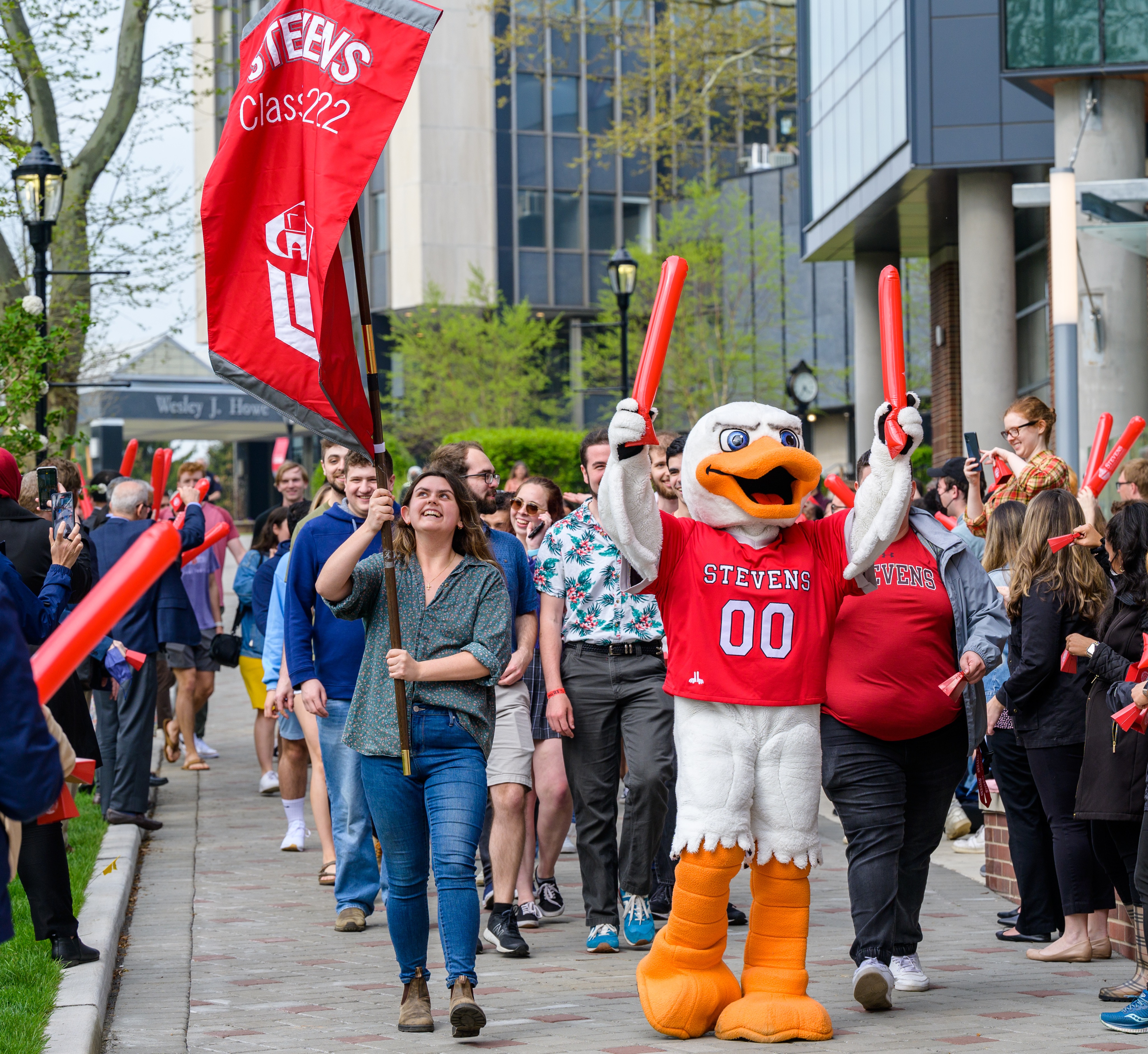 Graduating students walk on Wittpenn Walk with Attila and cheering crowds