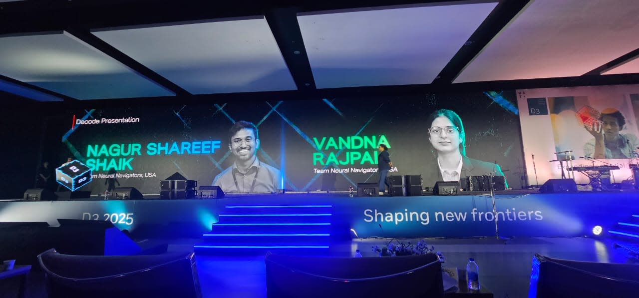 Team Neural Navigators members Vadna Rajpal and Nagur Shareef Shaik walk on a stage to present their solution, PRISM. 