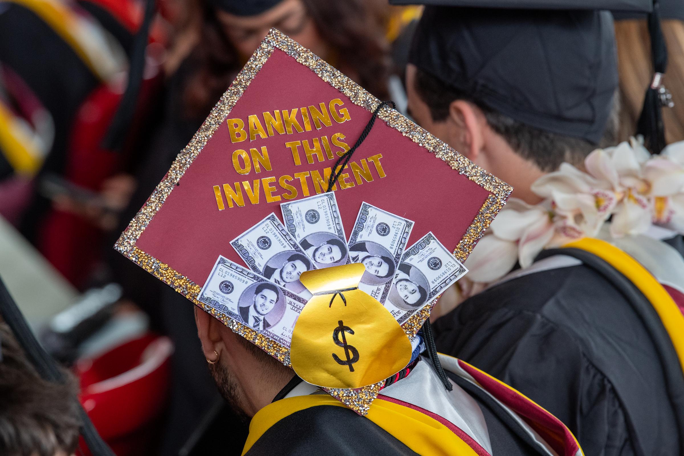 A decorated cap reads 'Banking on this Investment' with dollars and a moneybag.
