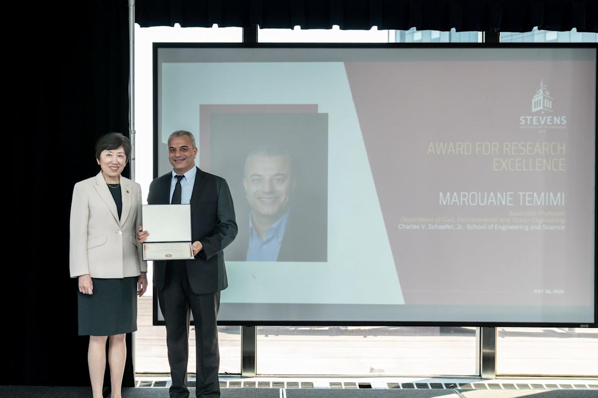 Jean Zu on the right and Marouane on the left who is receiving an award and poses for a photo with Jean.