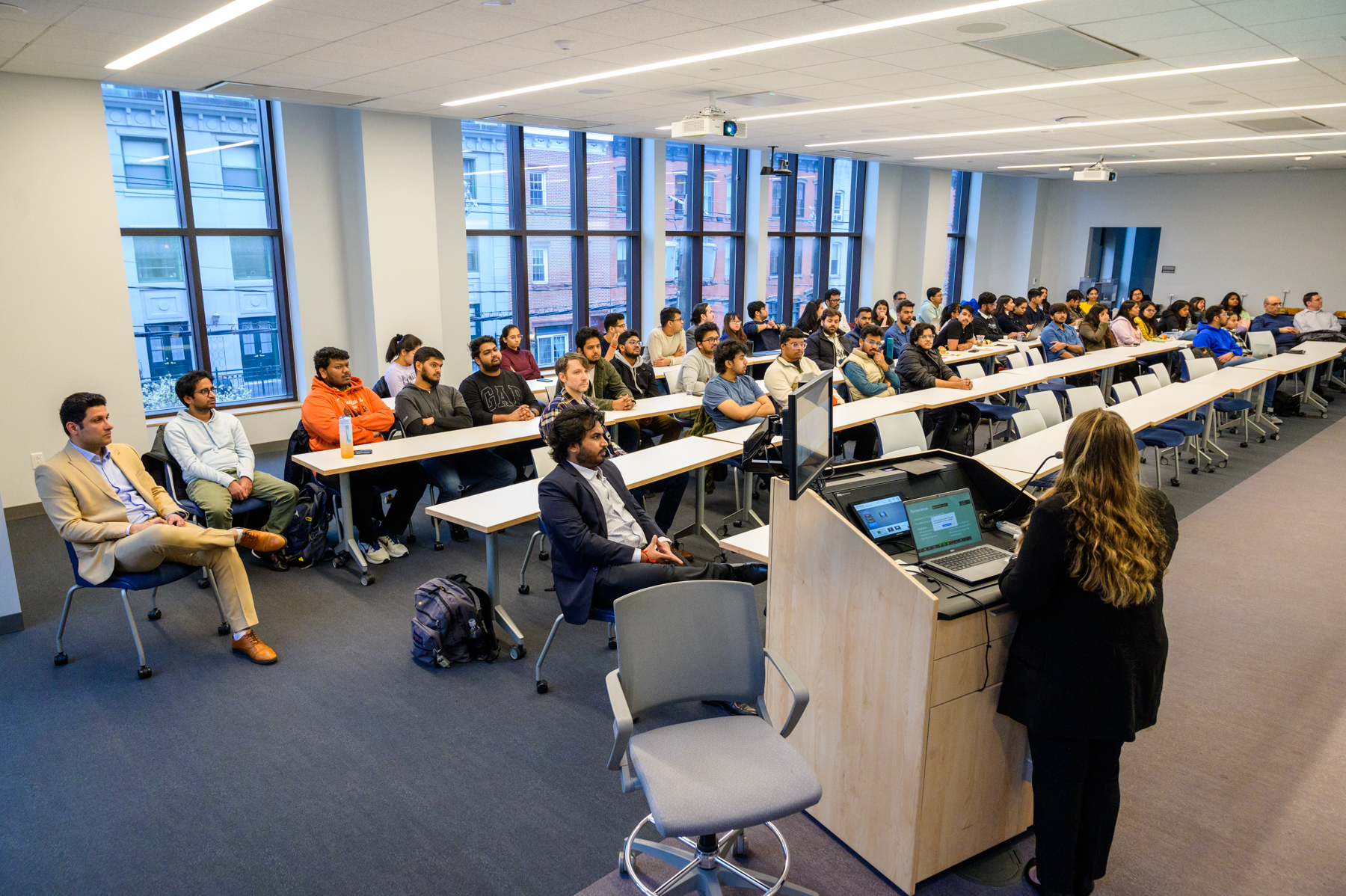 A full classroom of students listening intently to a lecture.