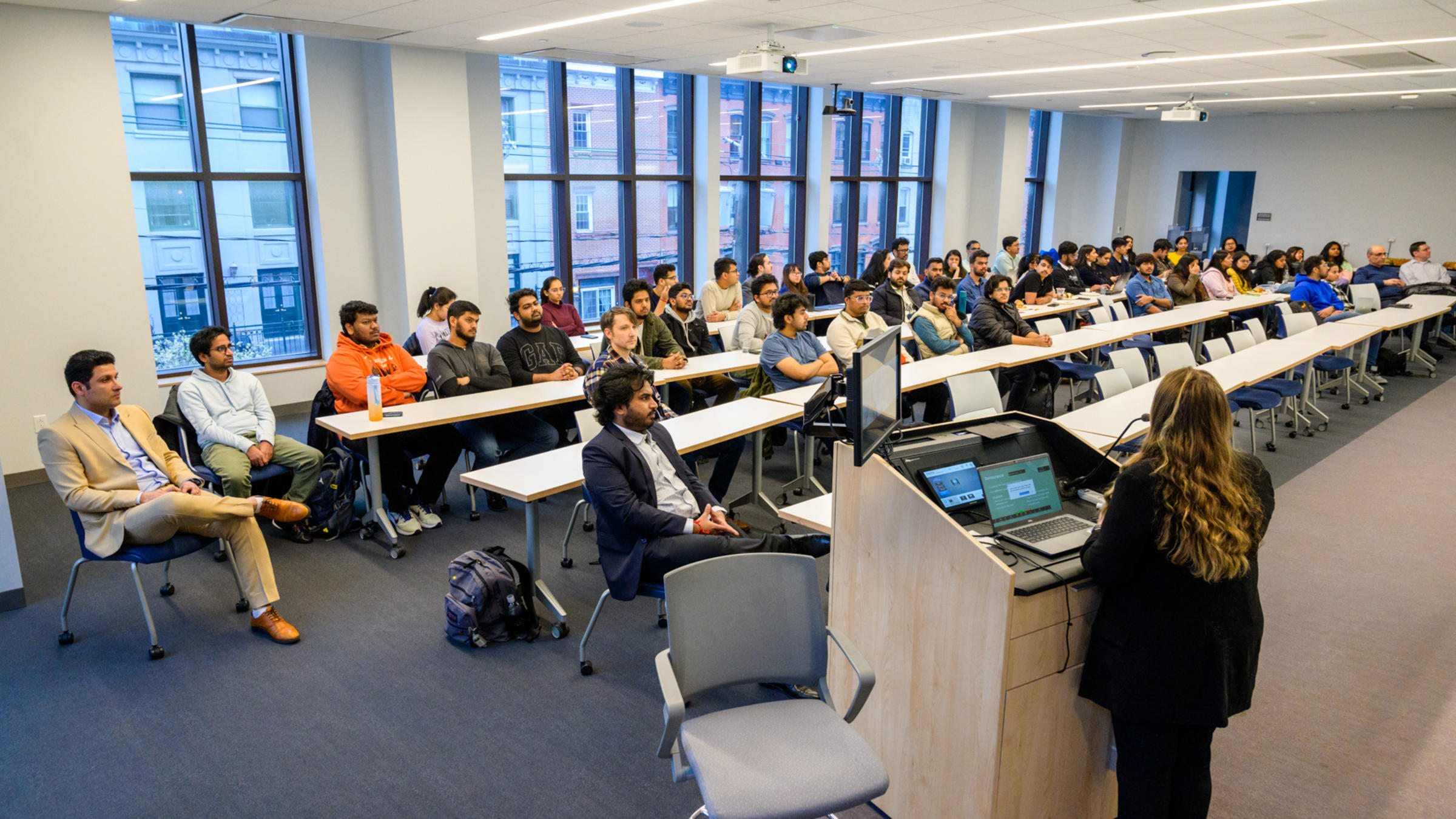 A full classroom of students listening intently to a lecture.