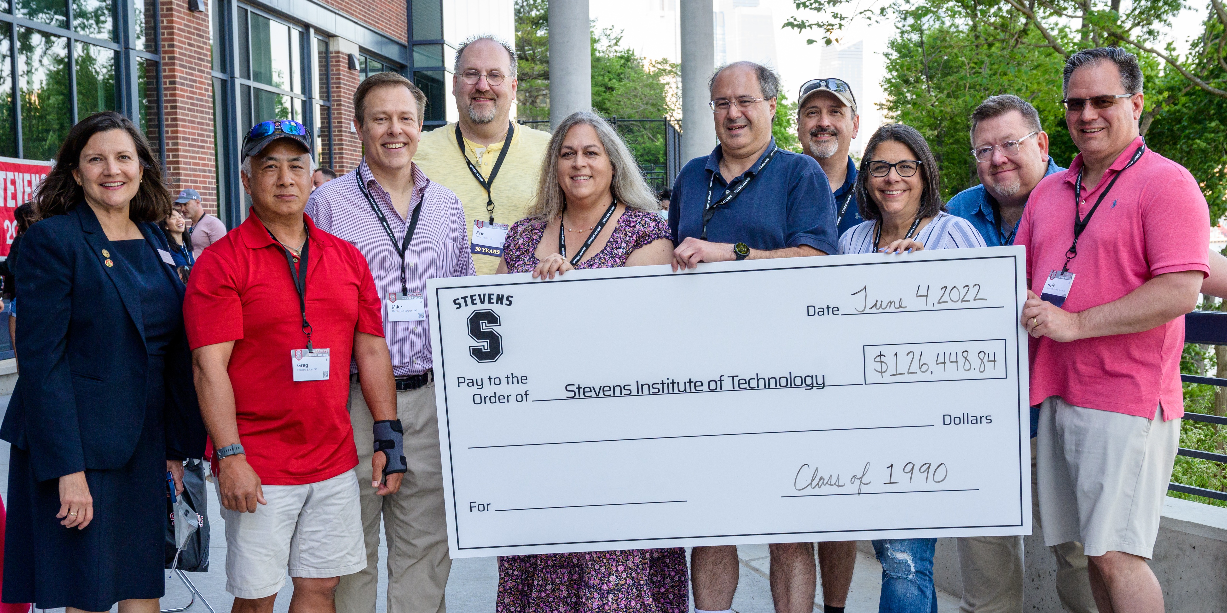 Large check presentation with group of alumni 