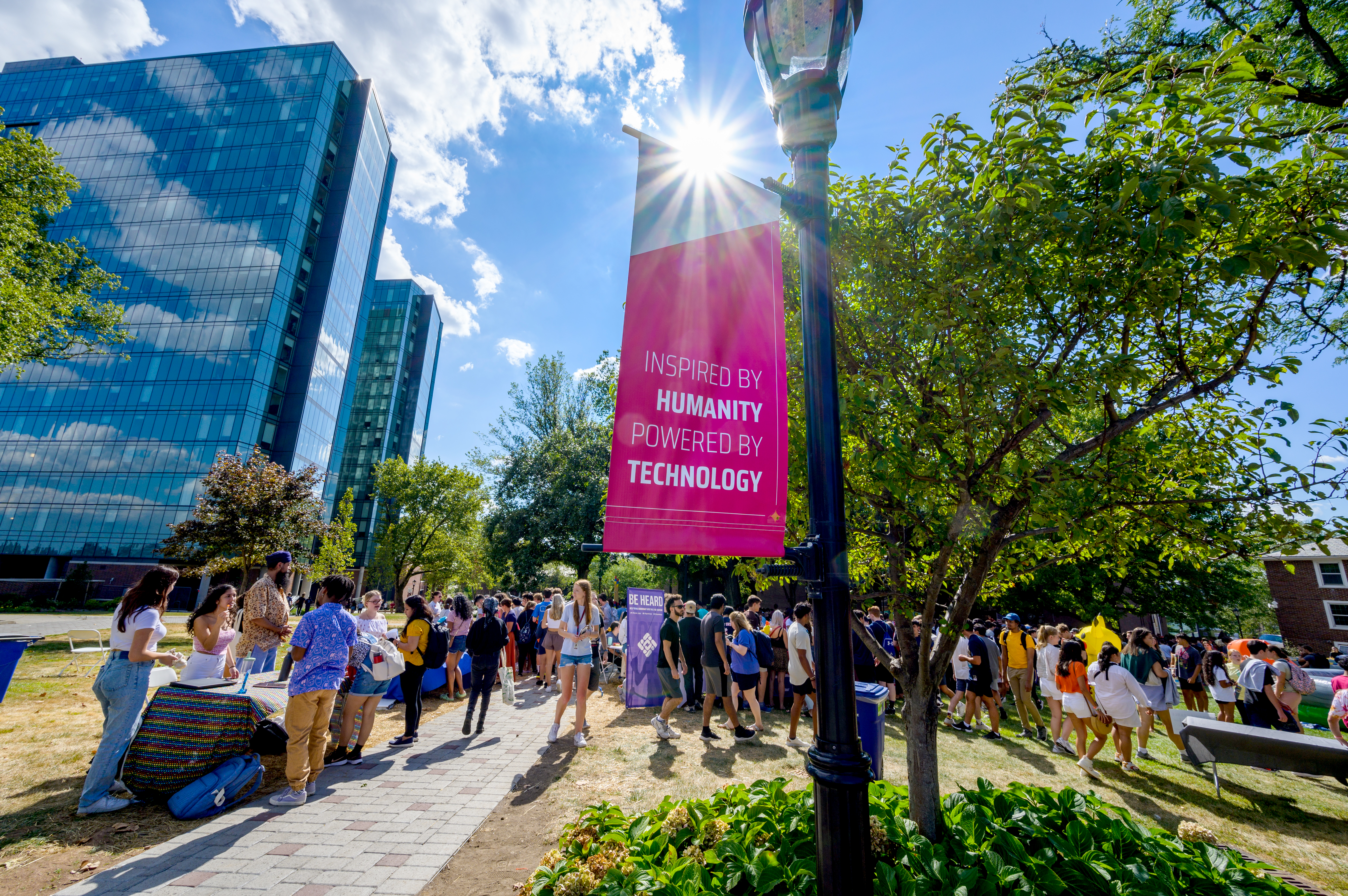 Event on Stevens campus with banner in foreground that reads "Inspired by Humanity, Powered by Technology"