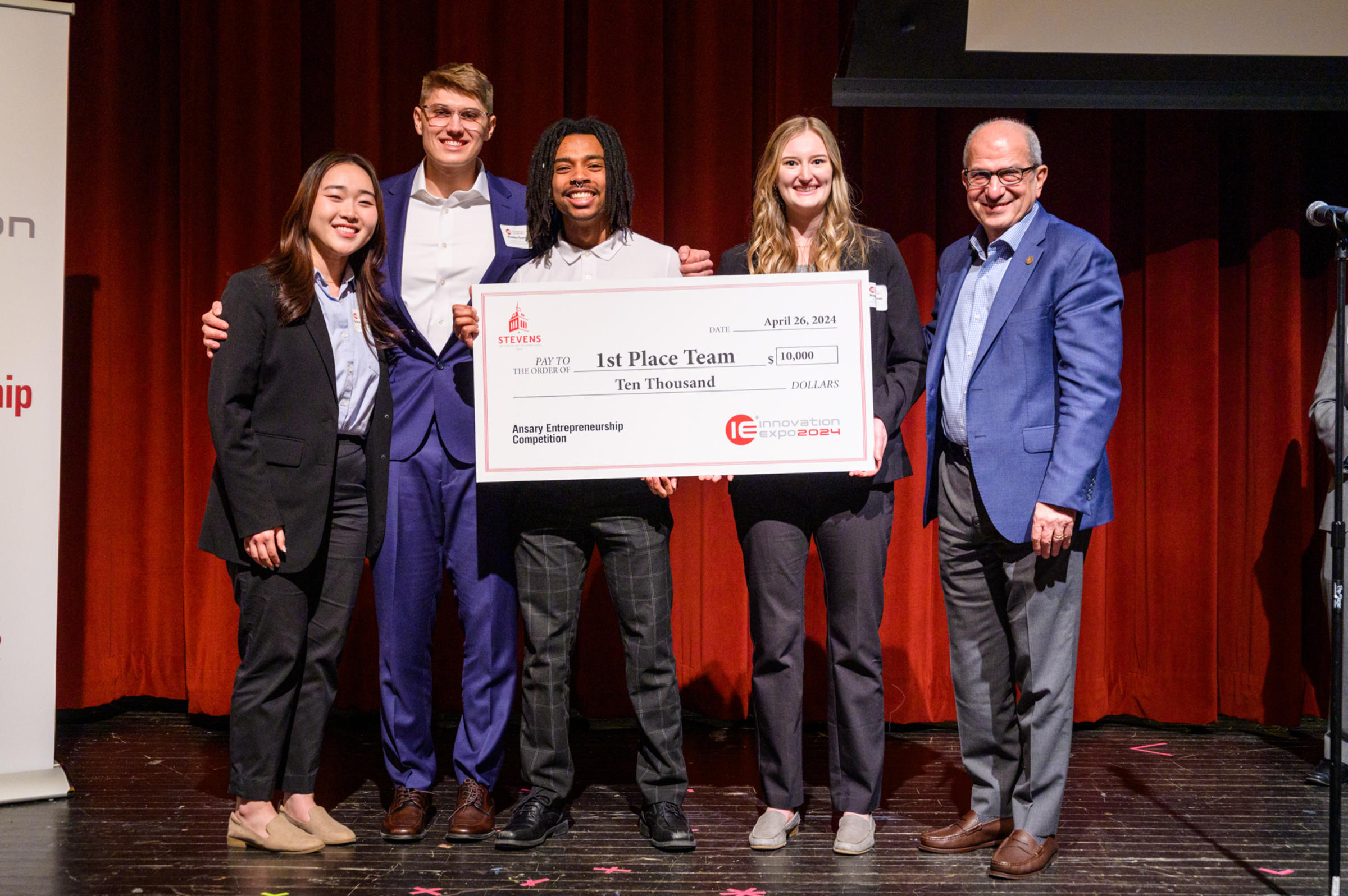 The Kneesy-Does It team accepts their first place check for ten thousand dollars in May 2024.