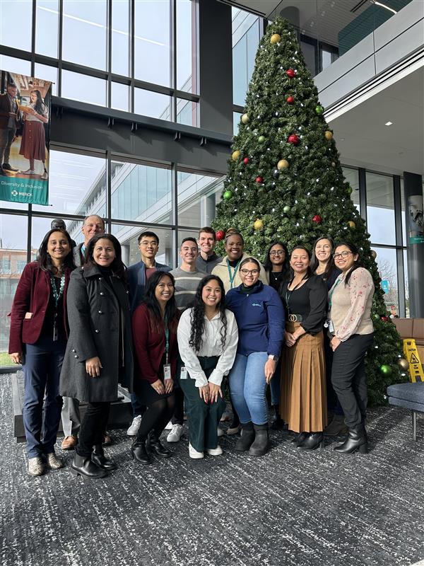 A group of alumni gather and smile for a photo during the alumni workplace engagement program