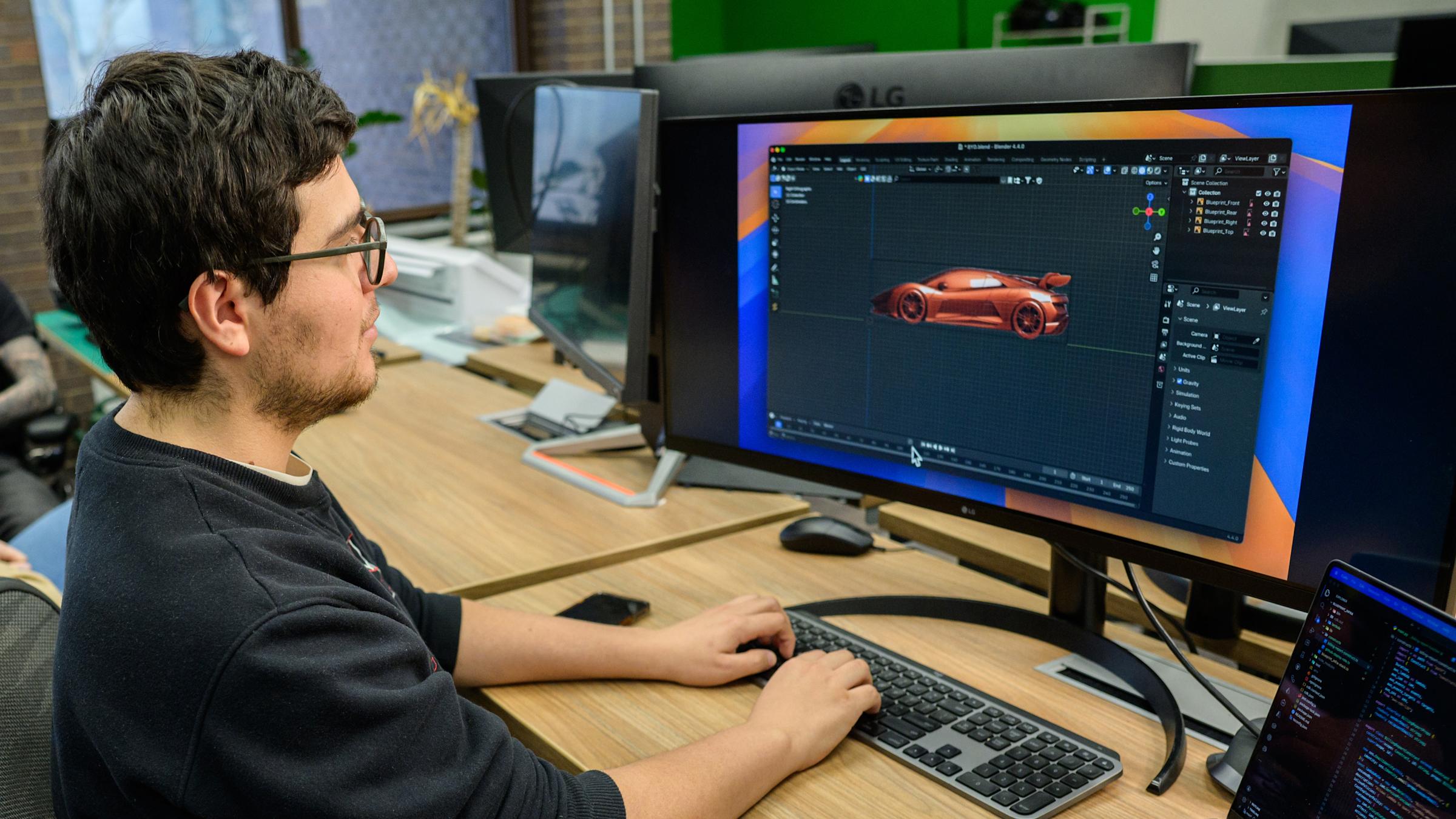 Male student working on a car design on a computer