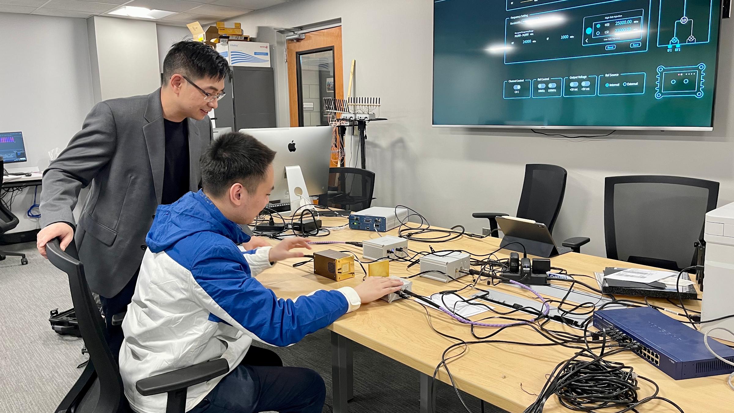 Shucheng showing students computer computations in his laboratory