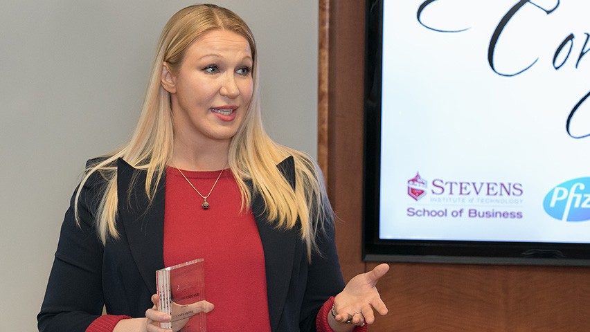 Cindy Dever accepts an award at a podium.