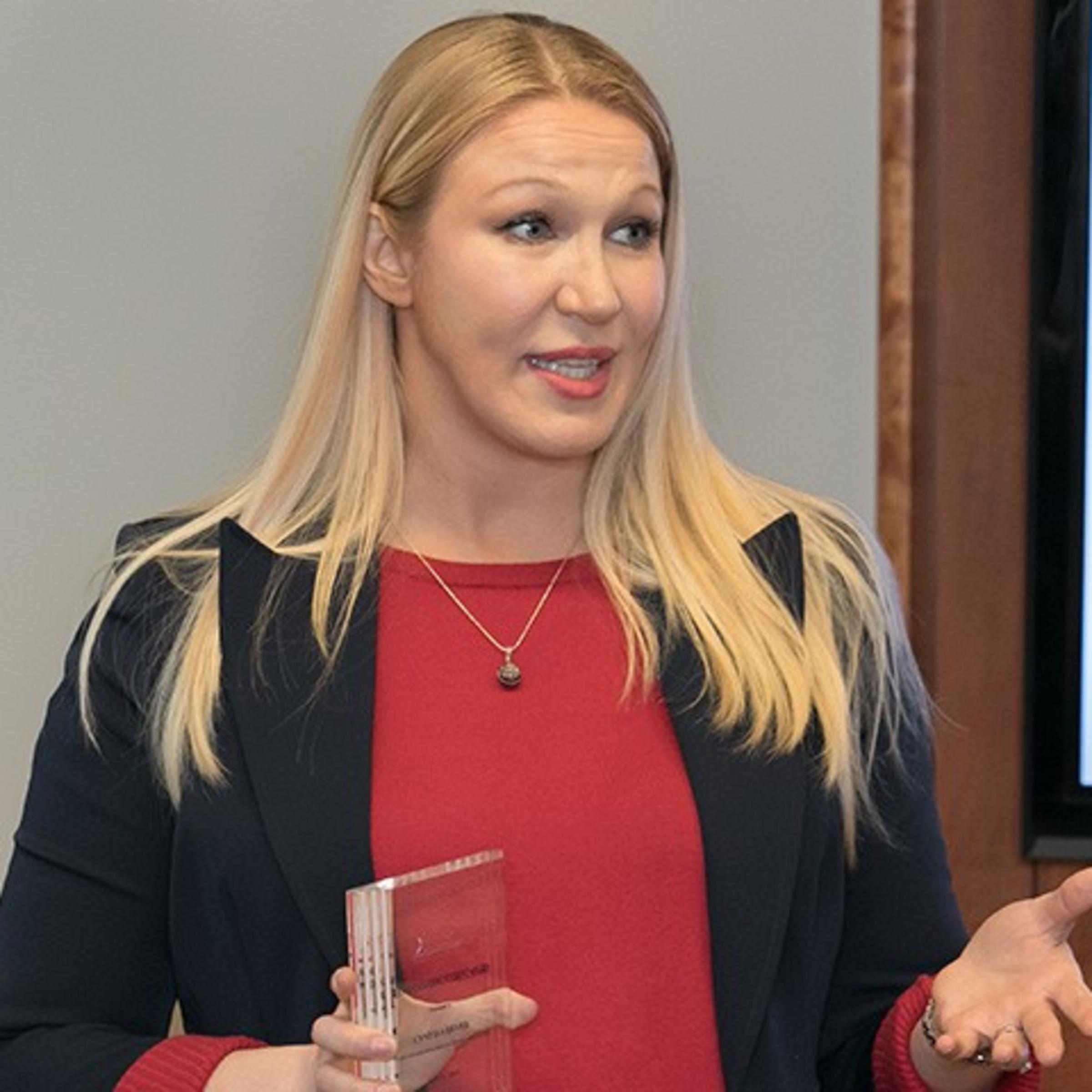 Cindy Dever accepts an award at a podium.