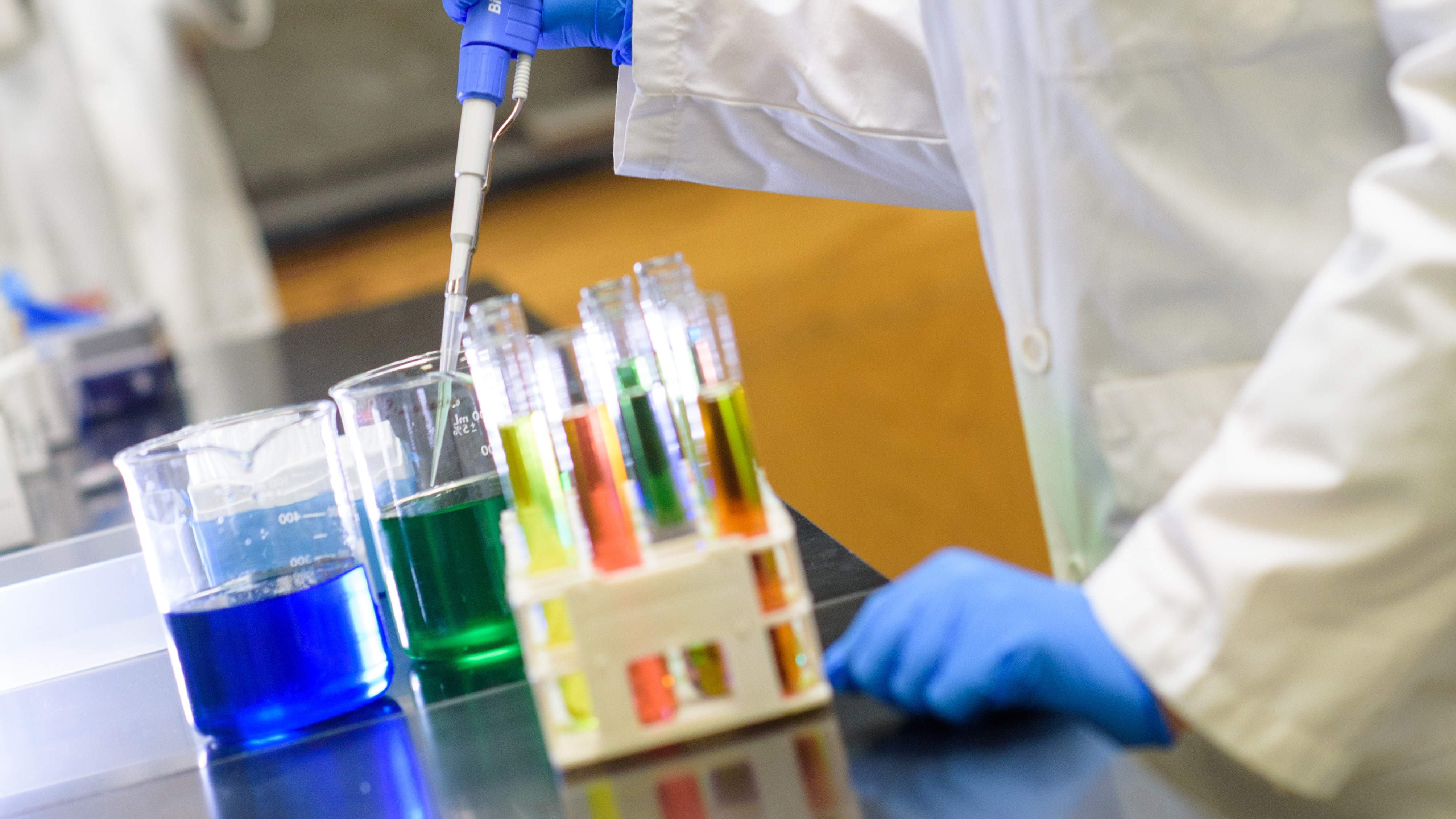 A student injecting liquid into a series of test tubes.