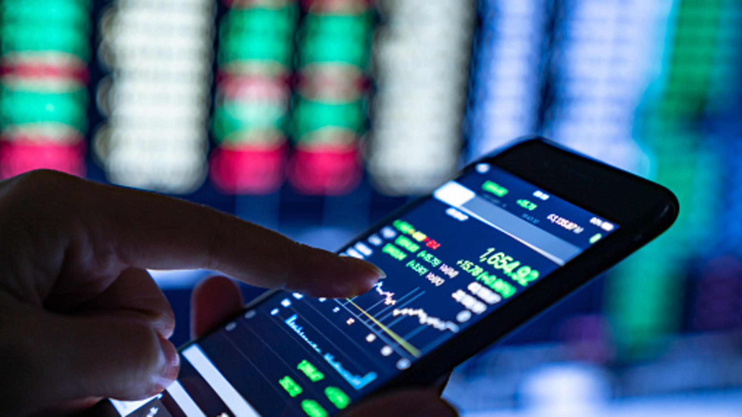 finger pointing to financial graph on phone