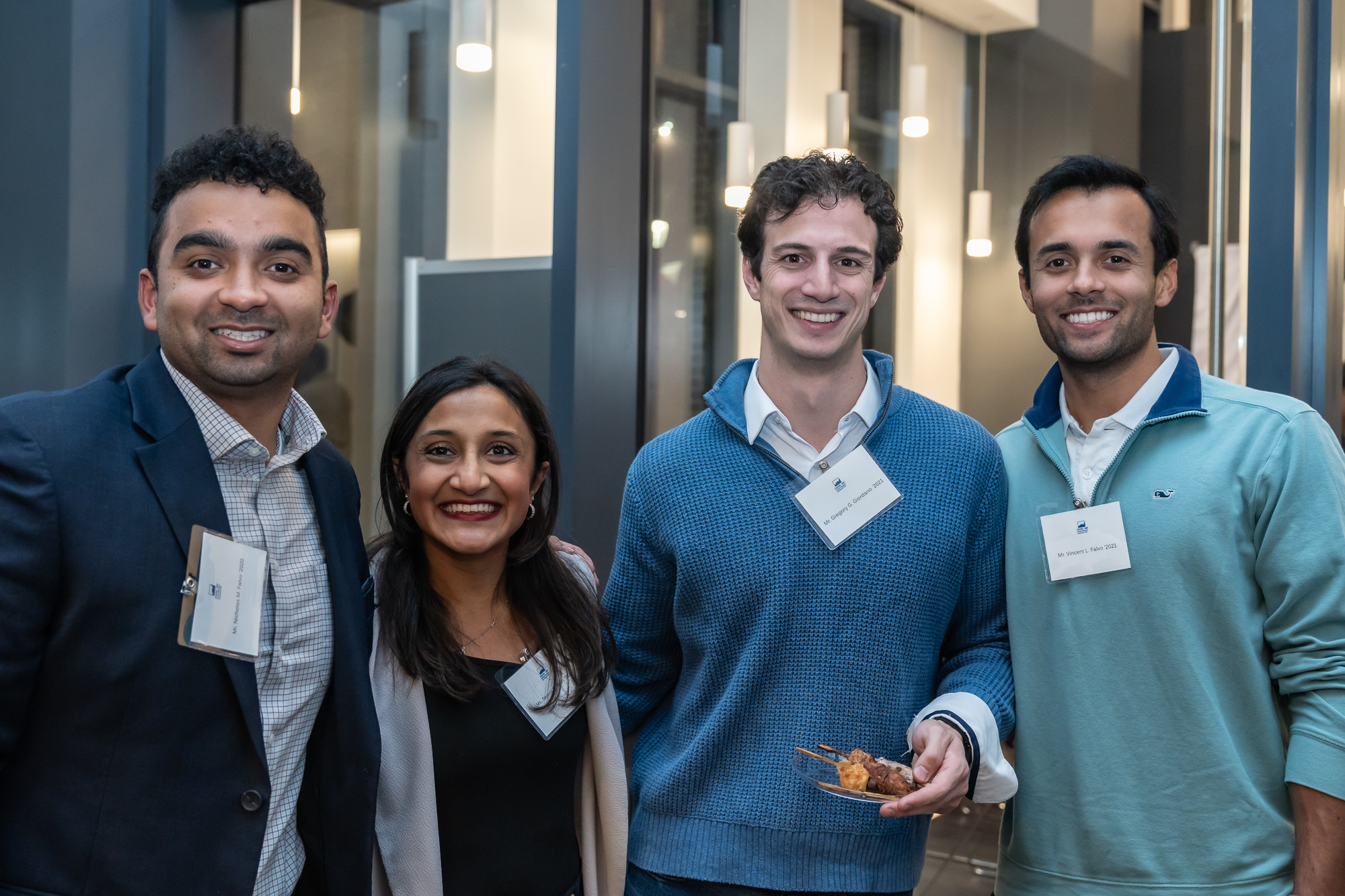 Four alumni pose for a group photo