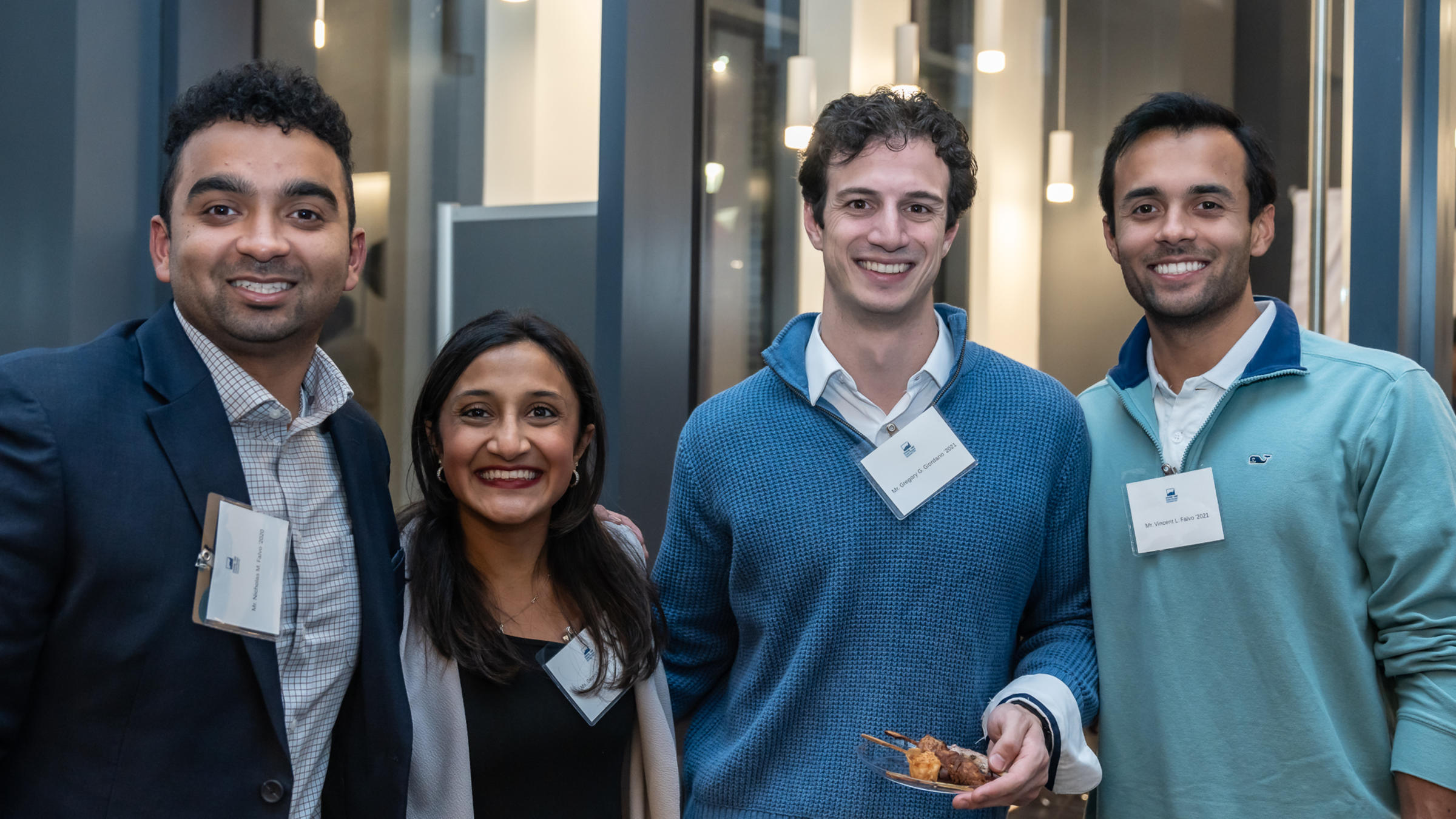 Four alumni pose for a group photo