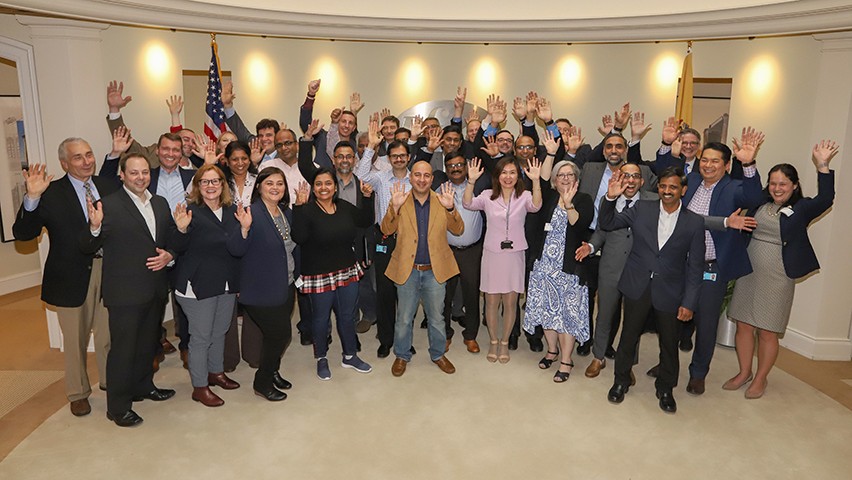A large group of Pfizer colleagues and Stevens faculty in Pfizer's offices, celebrating their recent graduation from the School of Business.