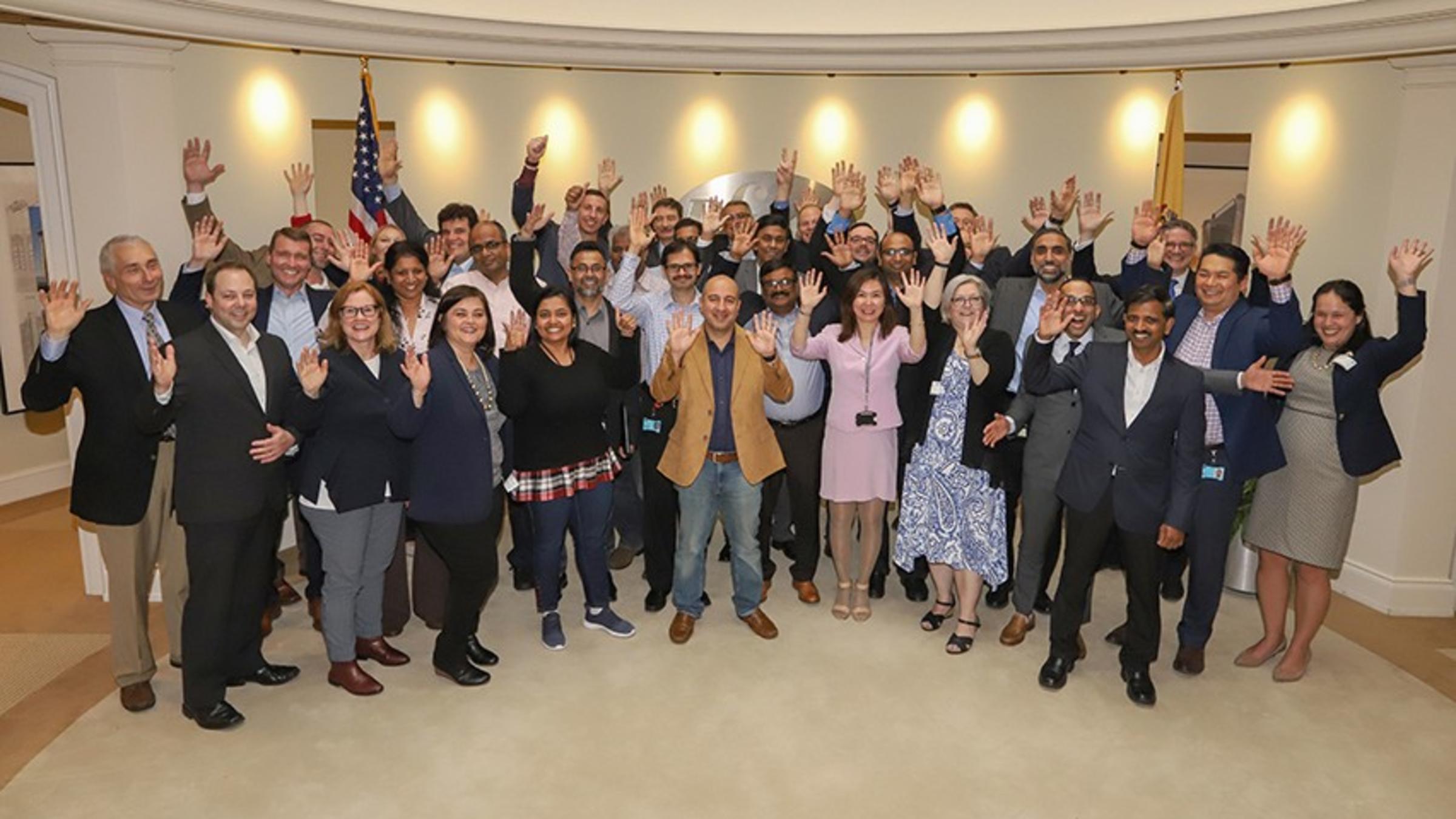 A large group of Pfizer colleagues and Stevens faculty in Pfizer's offices, celebrating their recent graduation from the School of Business.