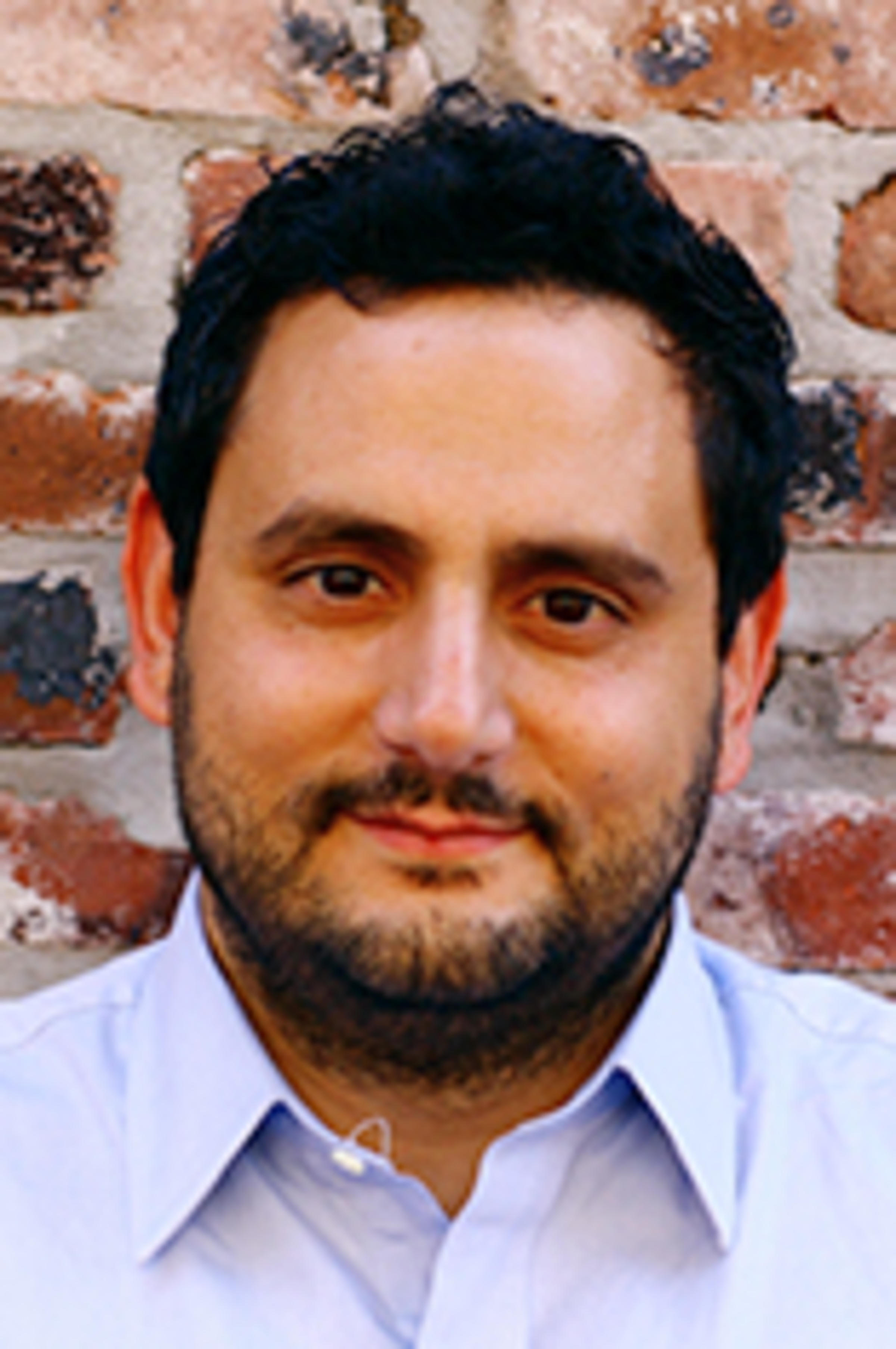 Headshot of Harris Kyriakou against a brick wall.