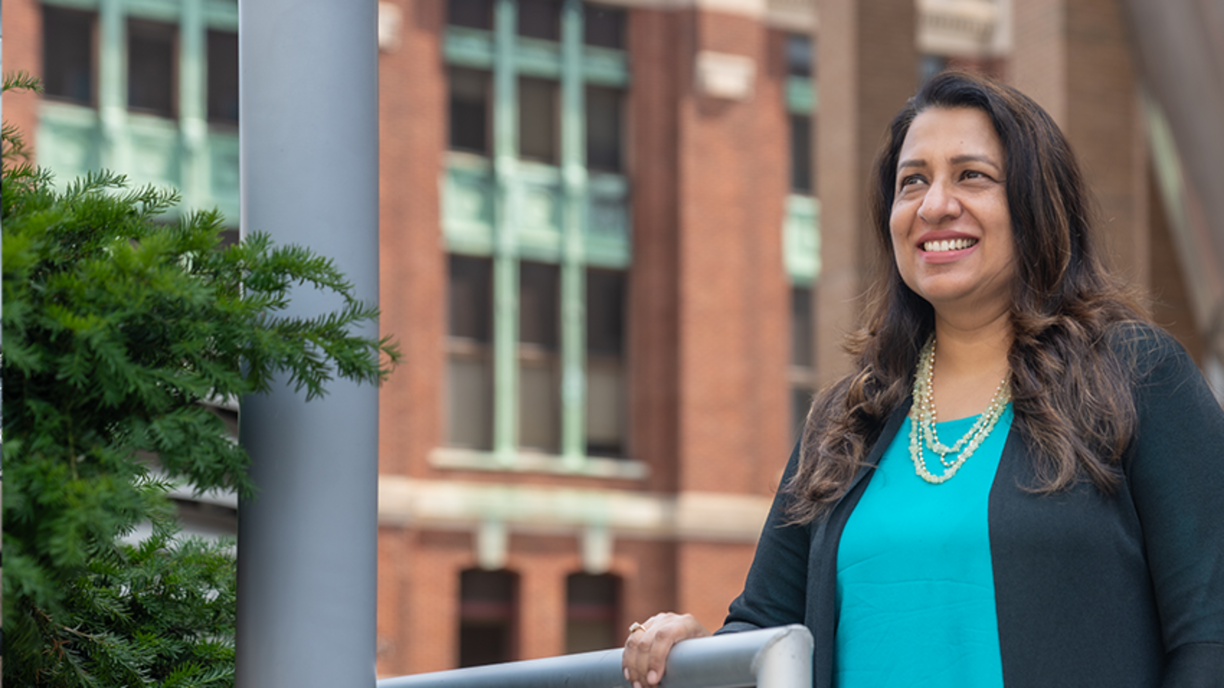 Ratika Gore looks outwards while standing on the balcony of the Babbio Center Plaza