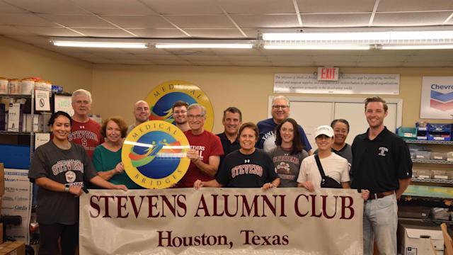 Members of the Houston Regional Network gather for a volunteering event and pose with the Stevens Alumni Club banner