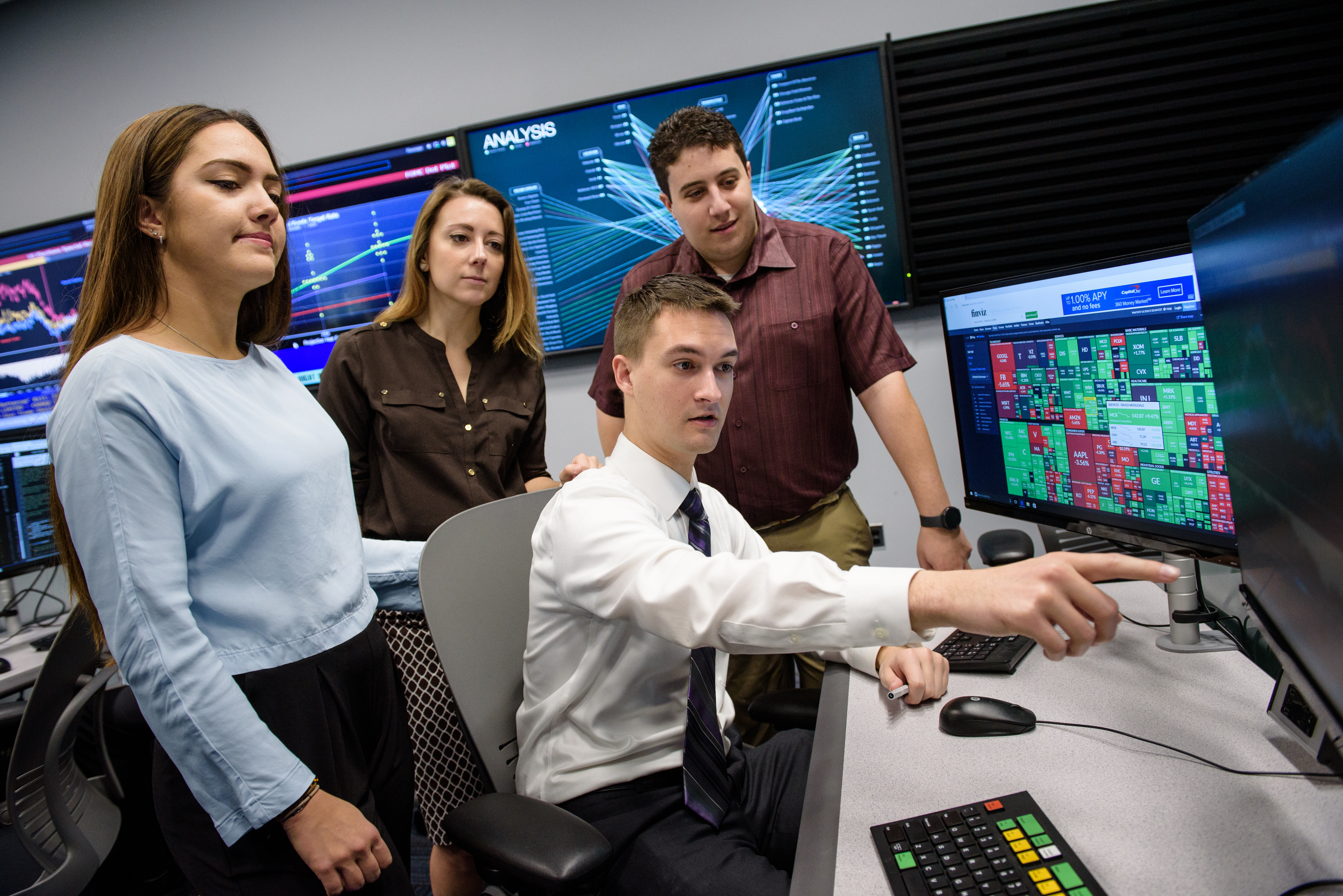 A group of students looking at monitors in the Hanlon Financial Center.