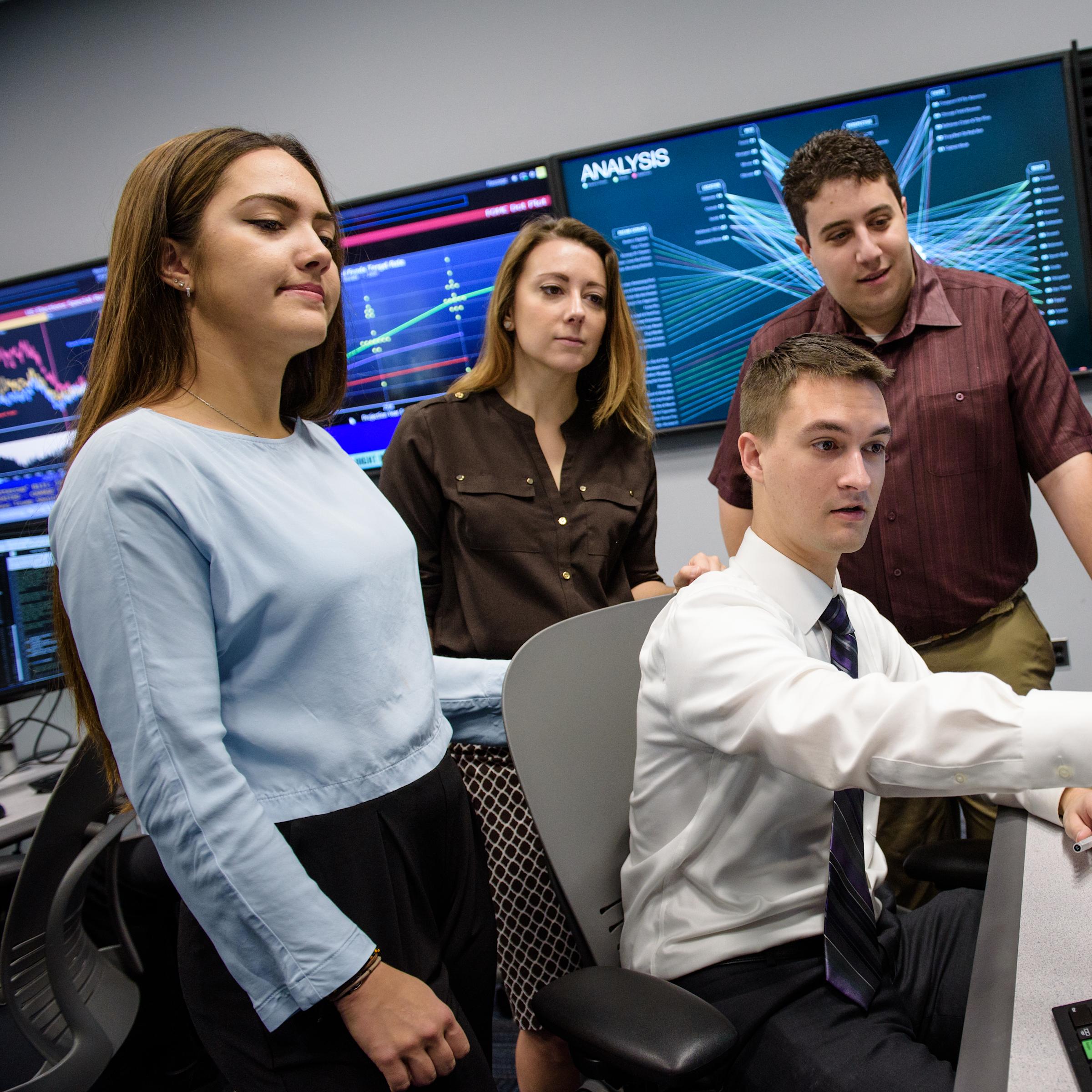 A group of students looking at monitors in the Hanlon Financial Center.
