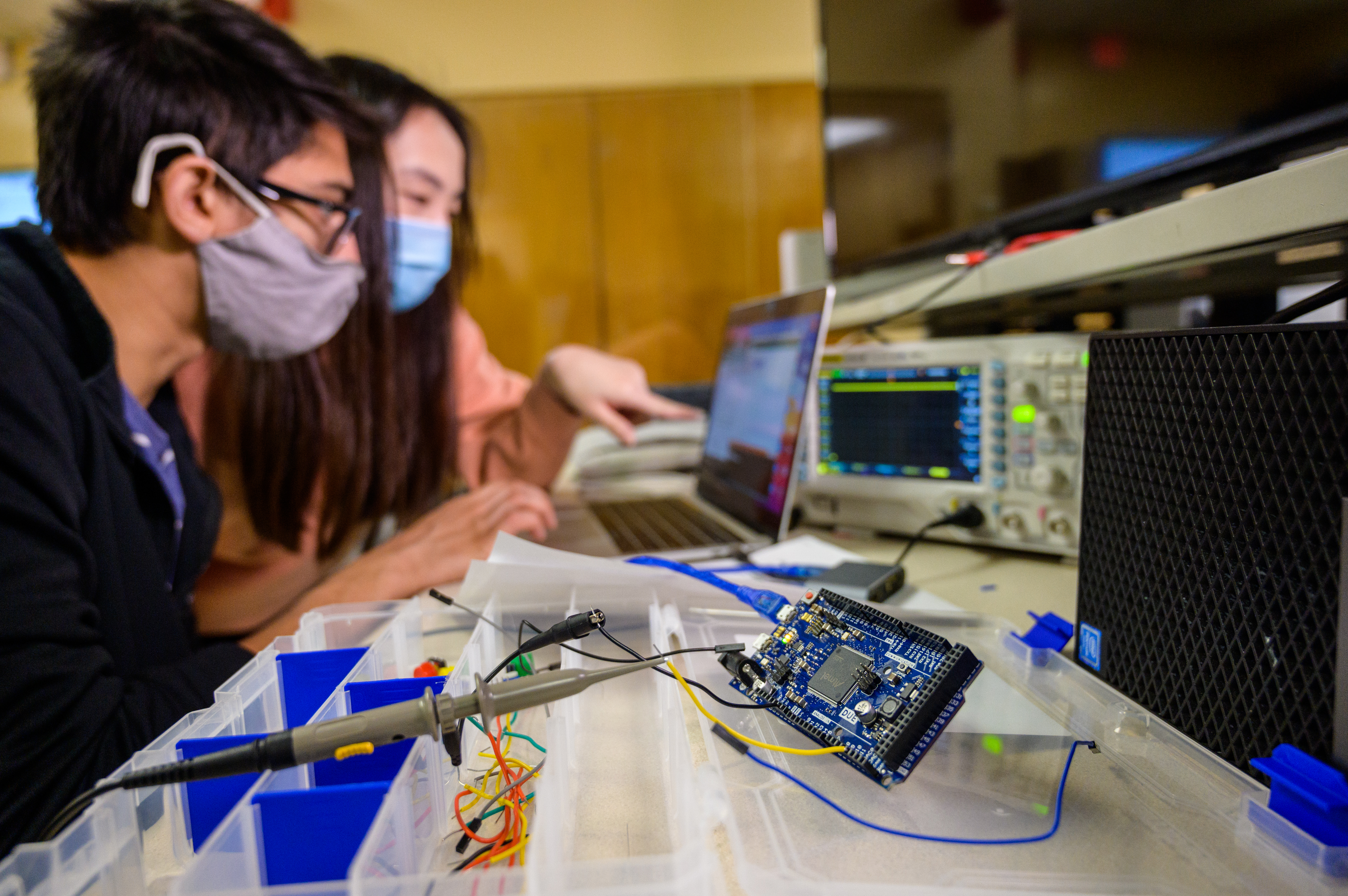 two students working on a project and looking at a laptop