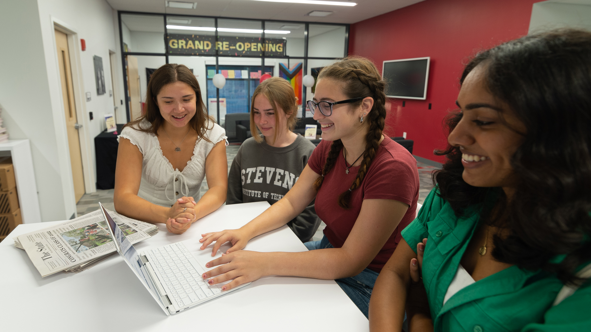 Staff members edit the Stute on their laptop.