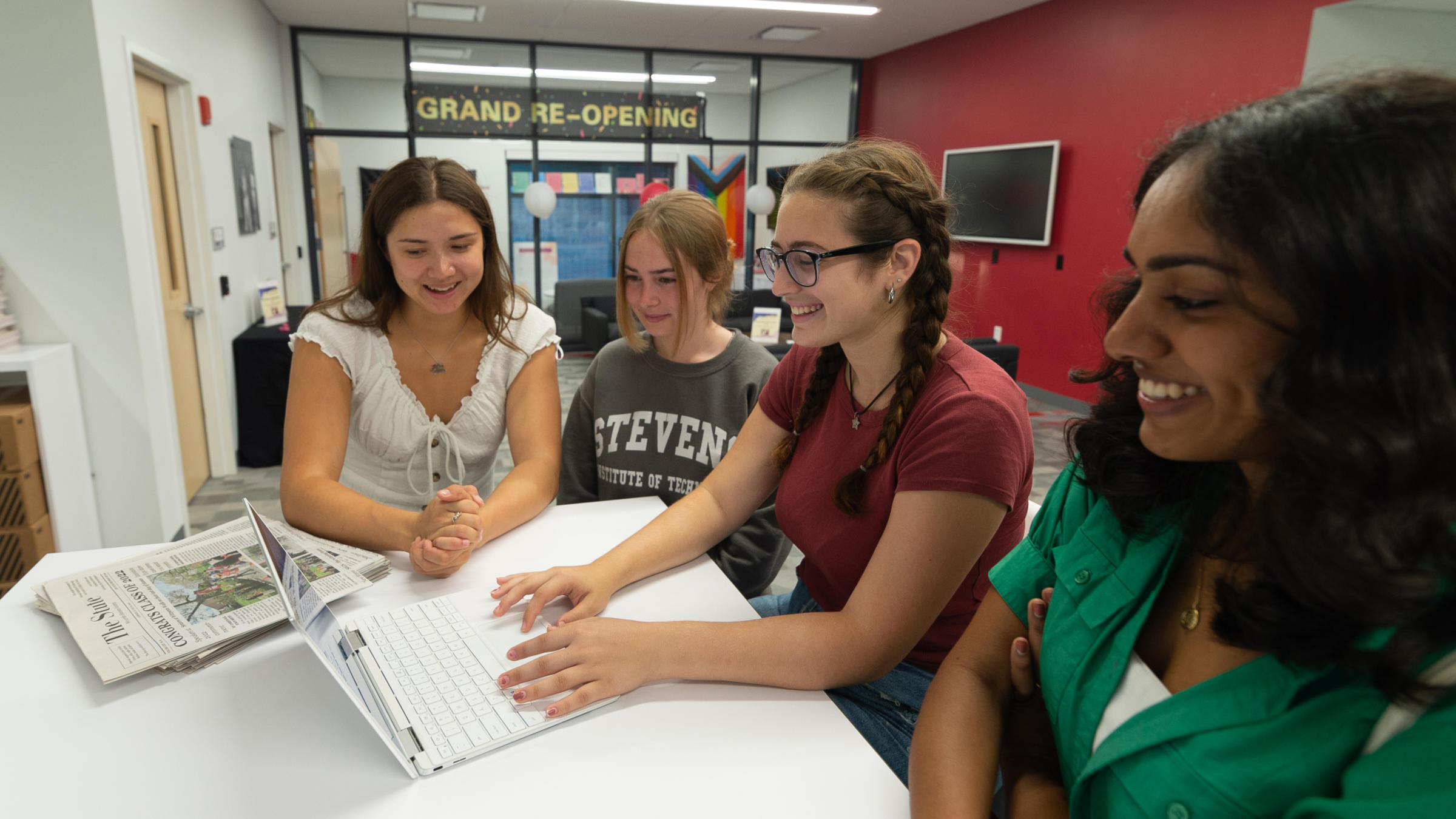 Staff members edit the Stute on their laptop.
