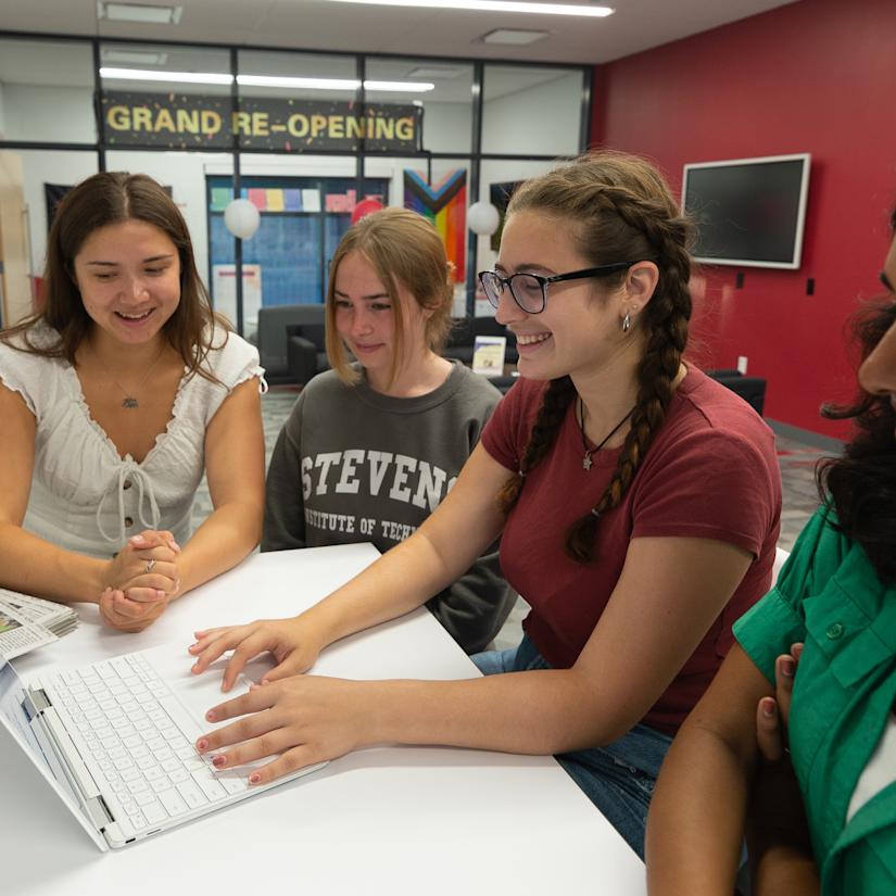 Staff members edit the Stute on their laptop.