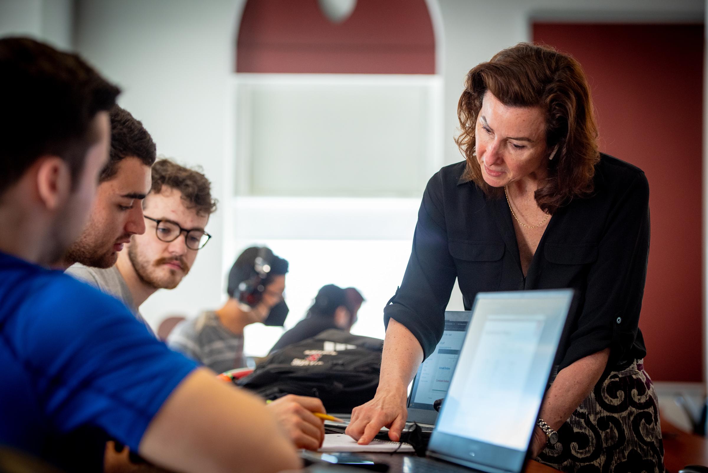 Instructor points to an equation in a students notebook