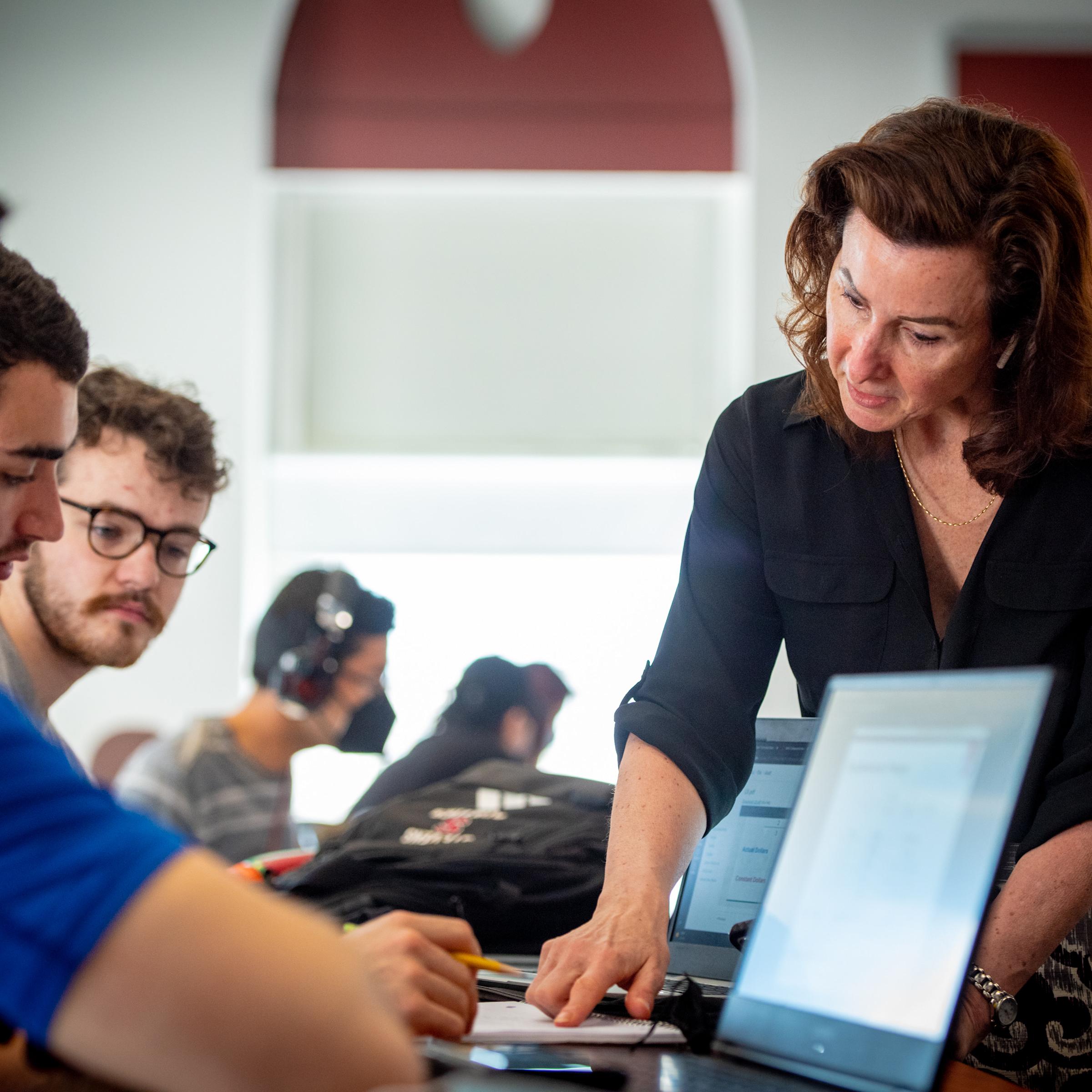 Instructor points to an equation in a students notebook