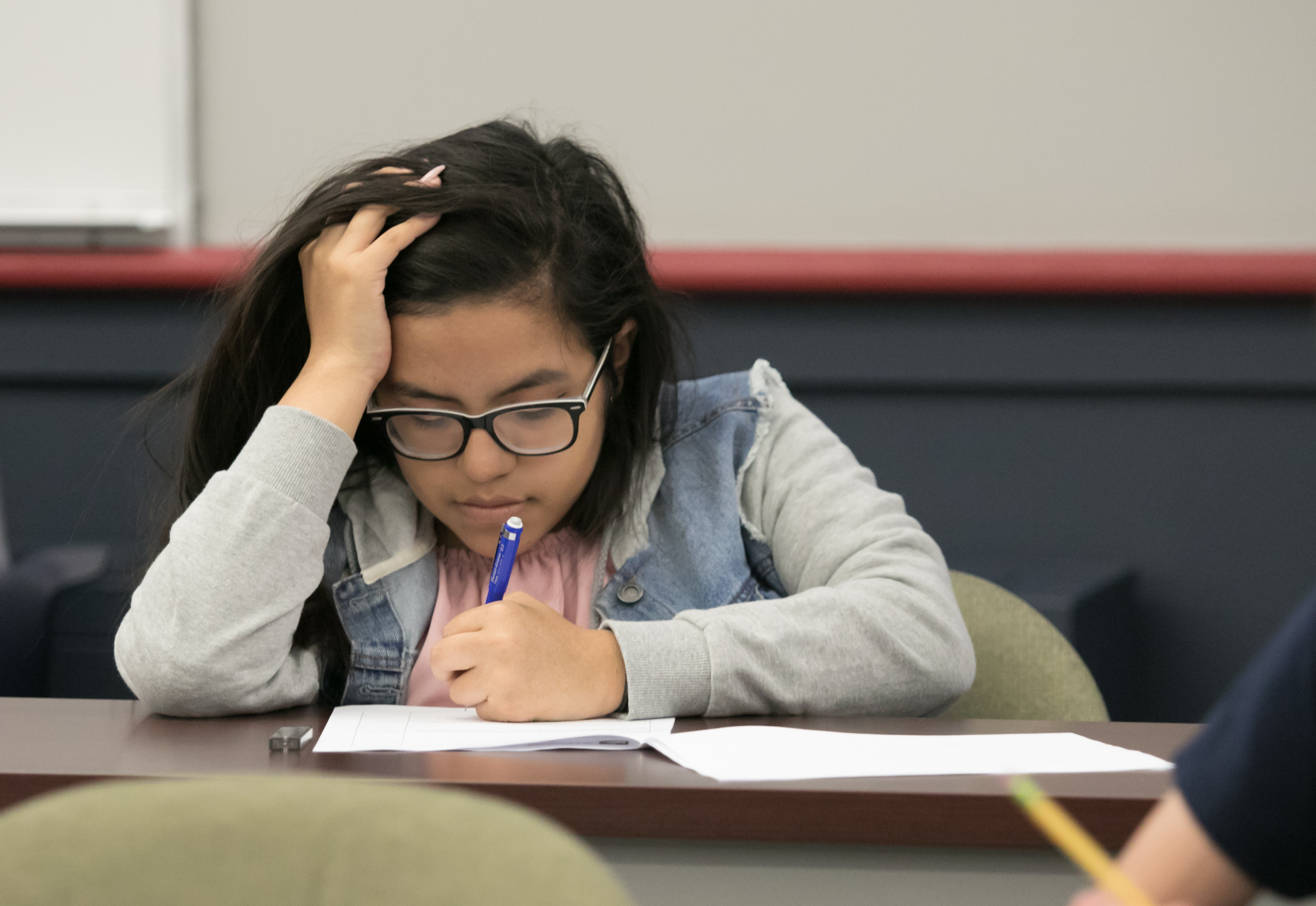 A young student concentrates as she works on a math problem