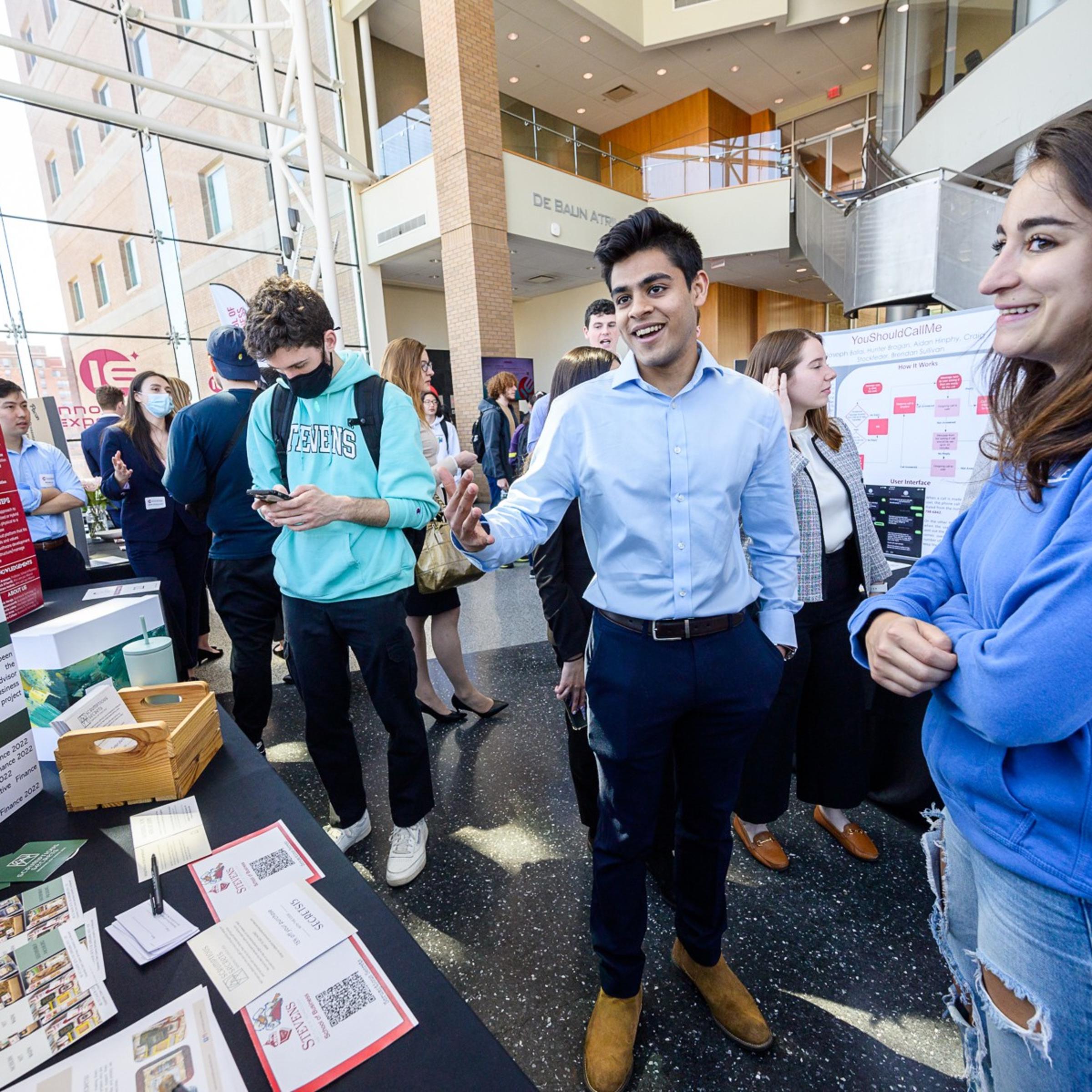 male student smiling and showing project during Stevens Innovation Expo