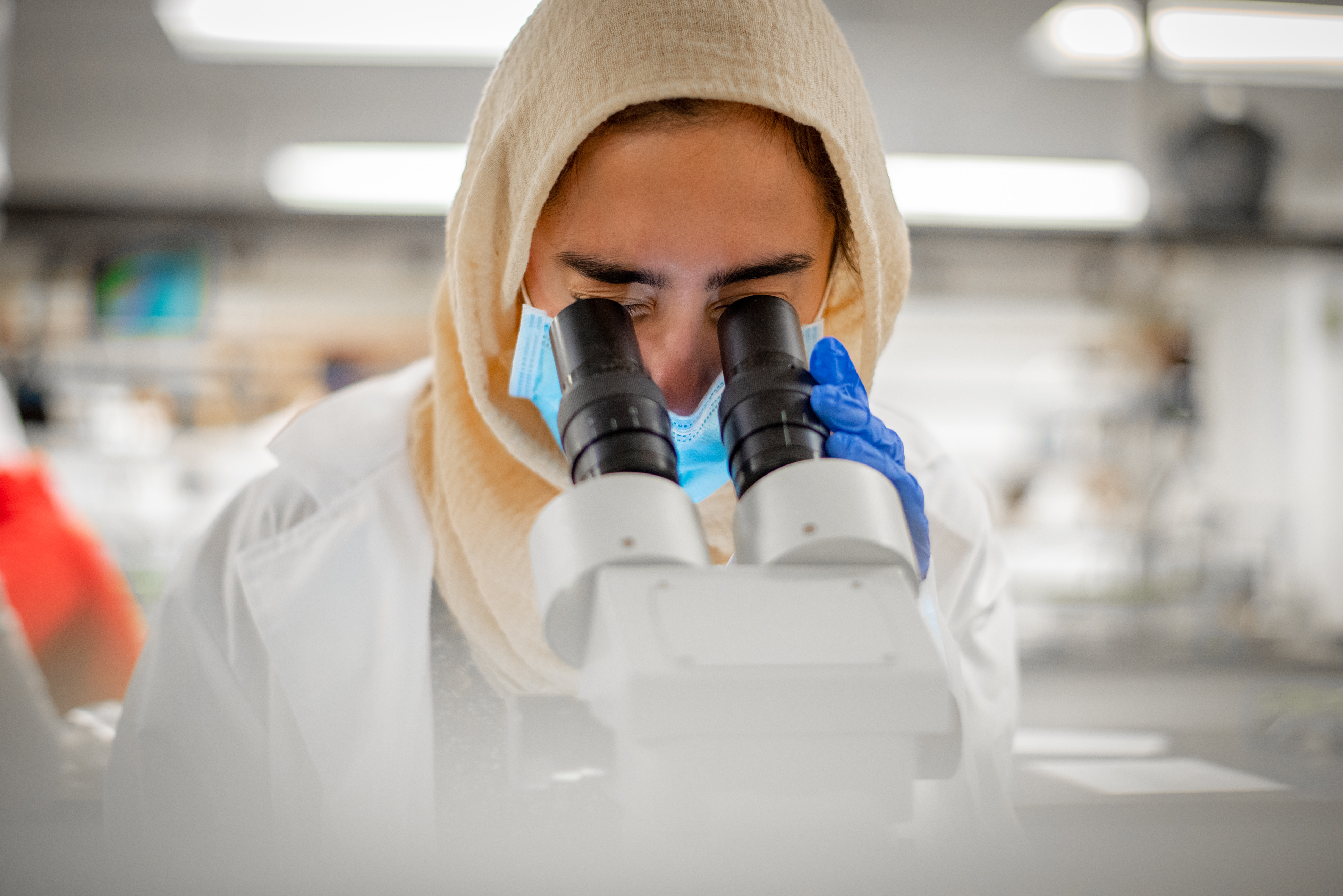 lab student looking into microscope