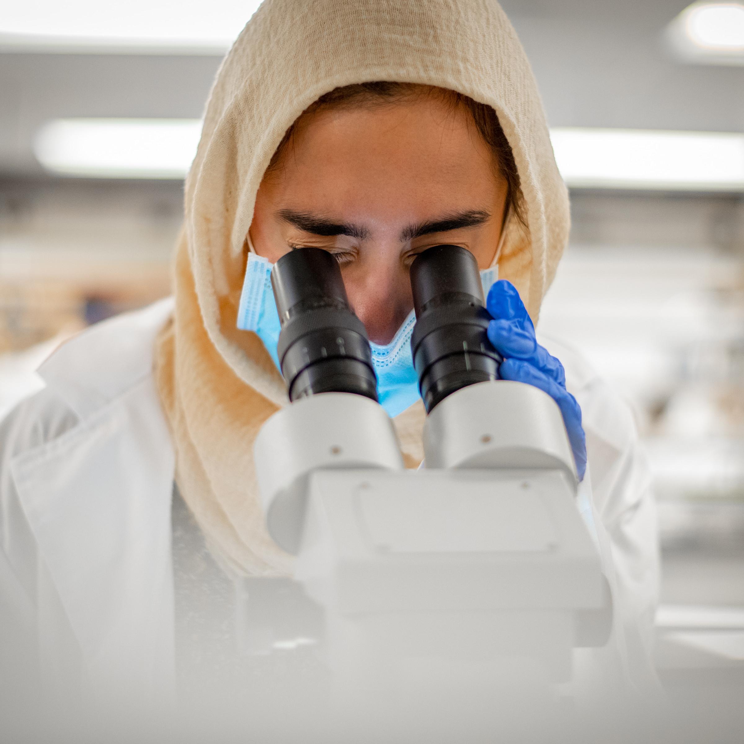 lab student looking into microscope