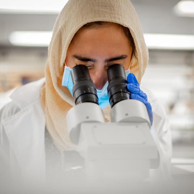 lab student looking into microscope