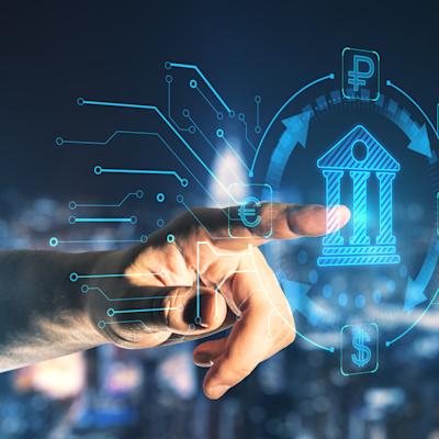 Hand pointing at a glowing blue hologram of a bank building, circled by exchange arrows linking euro, ruble, yen and dollar symbols, with circuit lines branching out against a blurred city skyline at night.