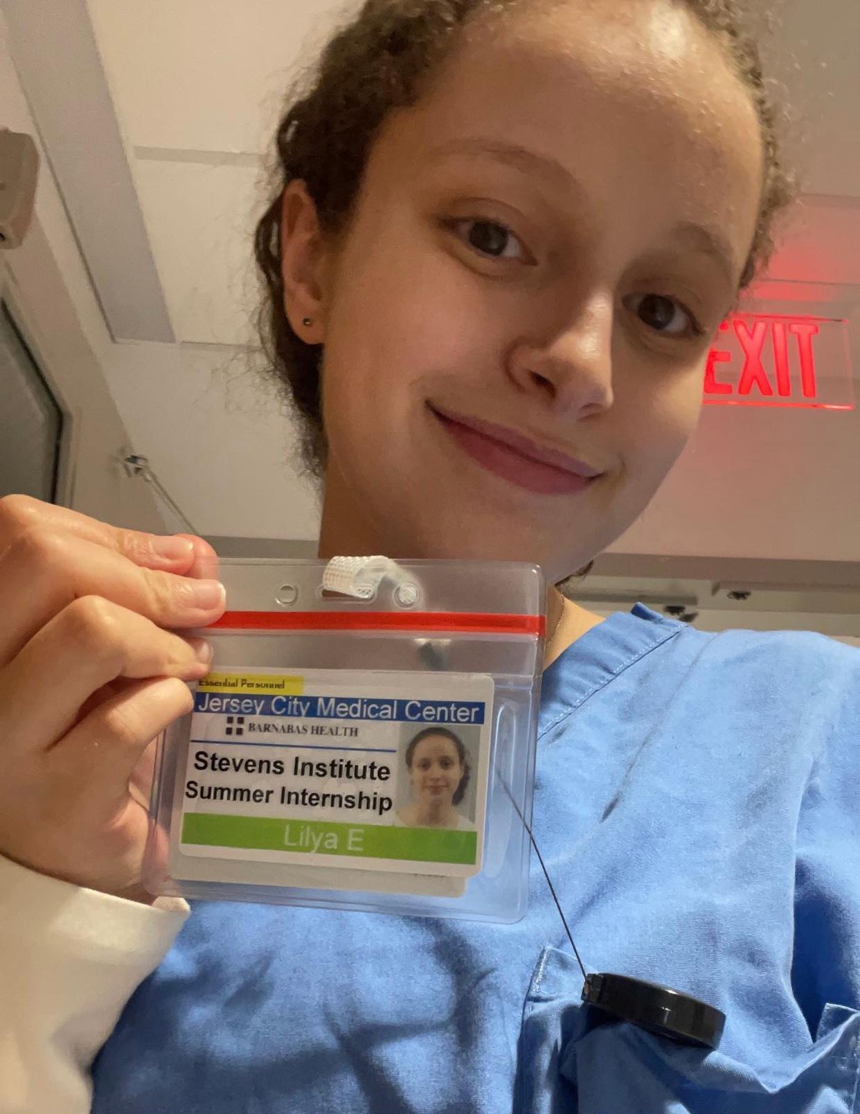 Photo of student Lilya Eid ‘26 holding her name badge, which also displays her name in print