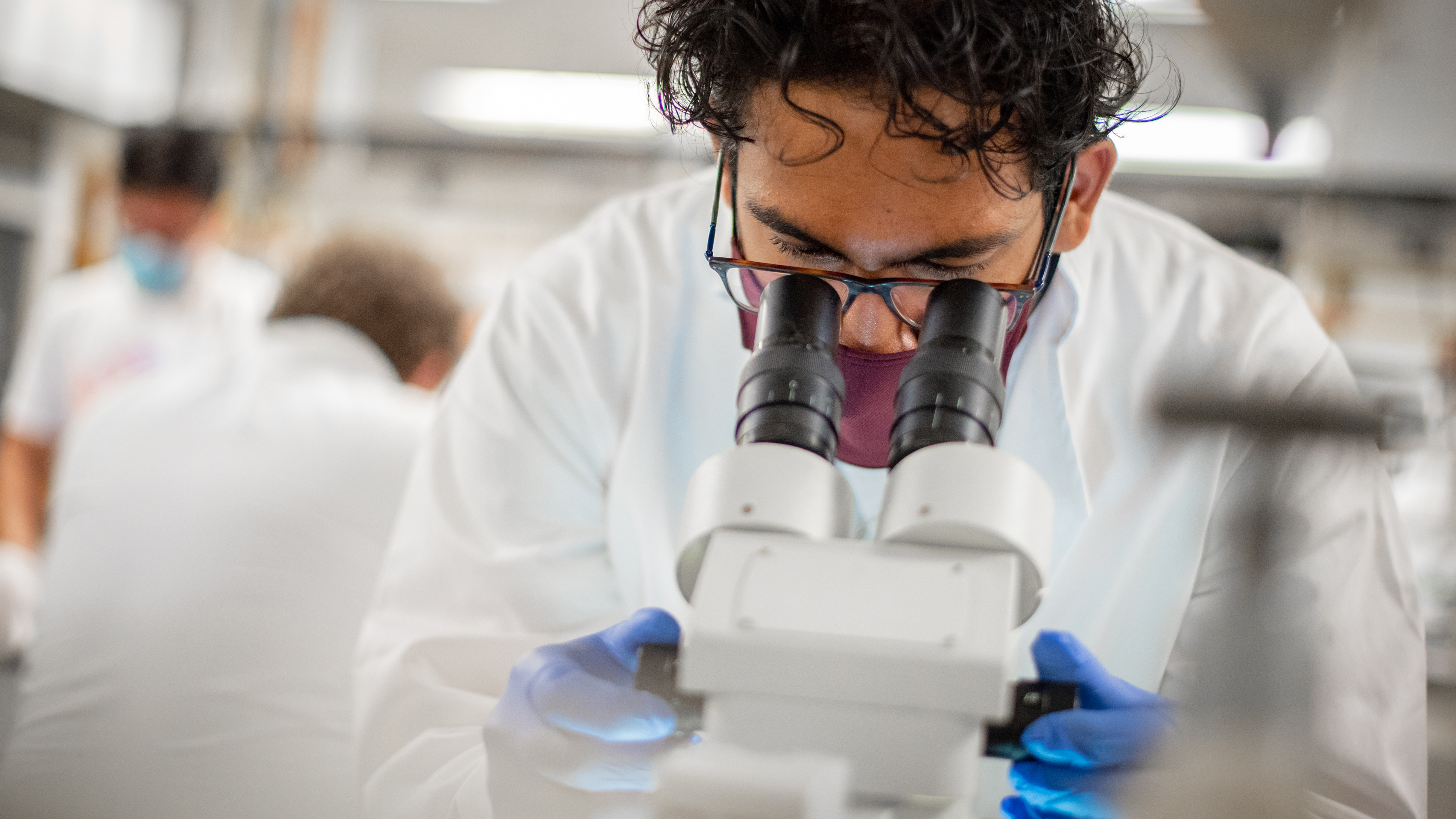 Male student looking in microscope