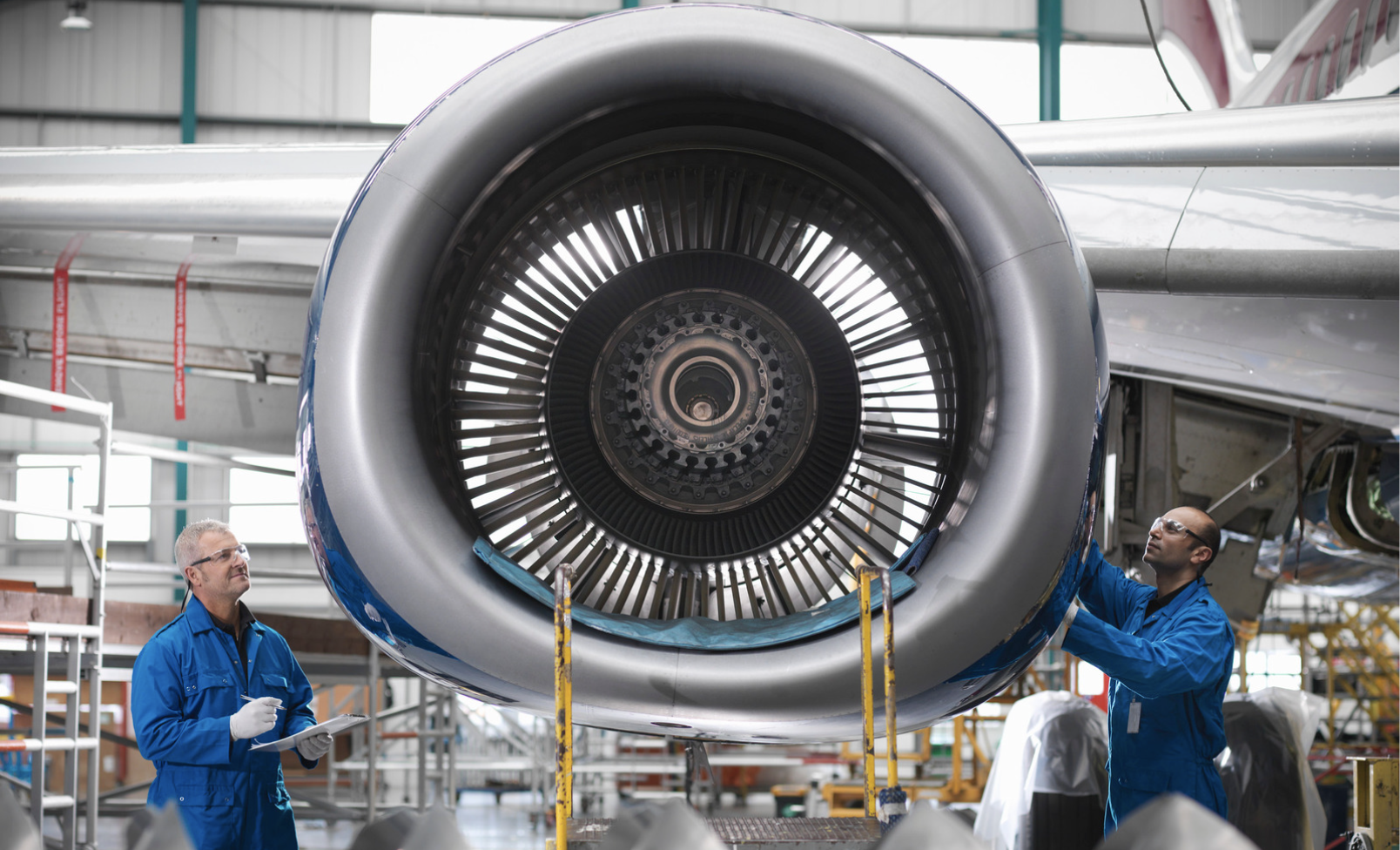 Aircraft engineers working on a 737 jet engine in airport