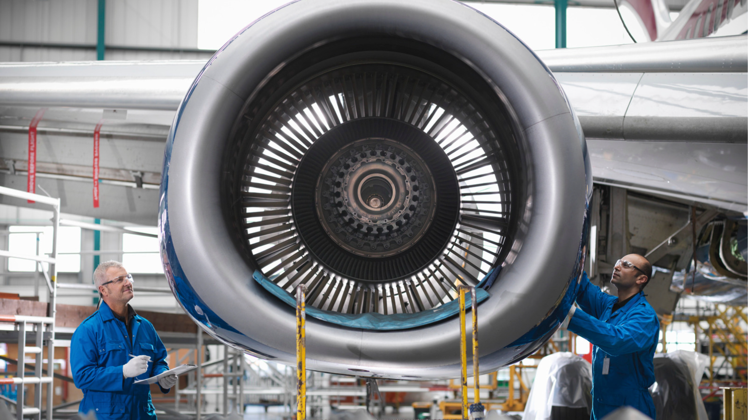 Aircraft engineers working on a 737 jet engine in airport