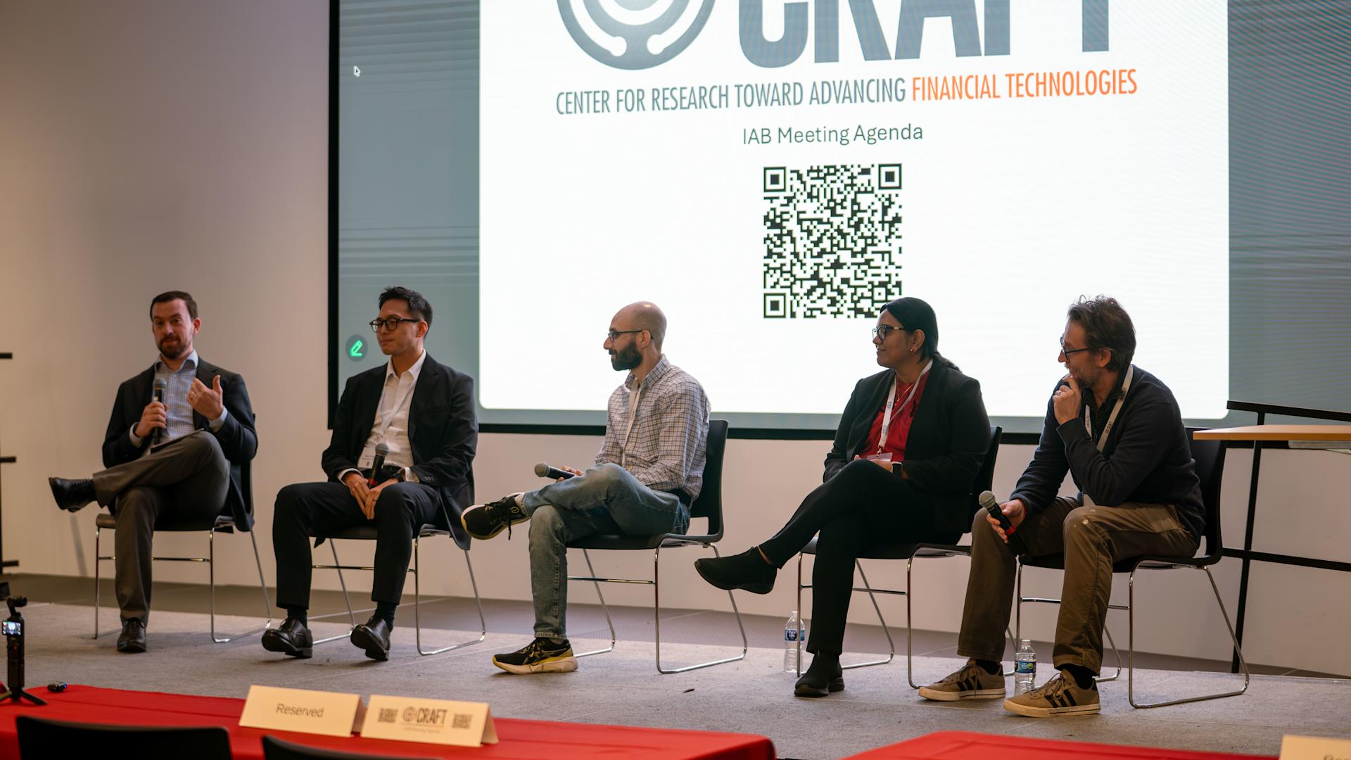 Five panelists sit on an elevated stage to discuss new fintech trends.